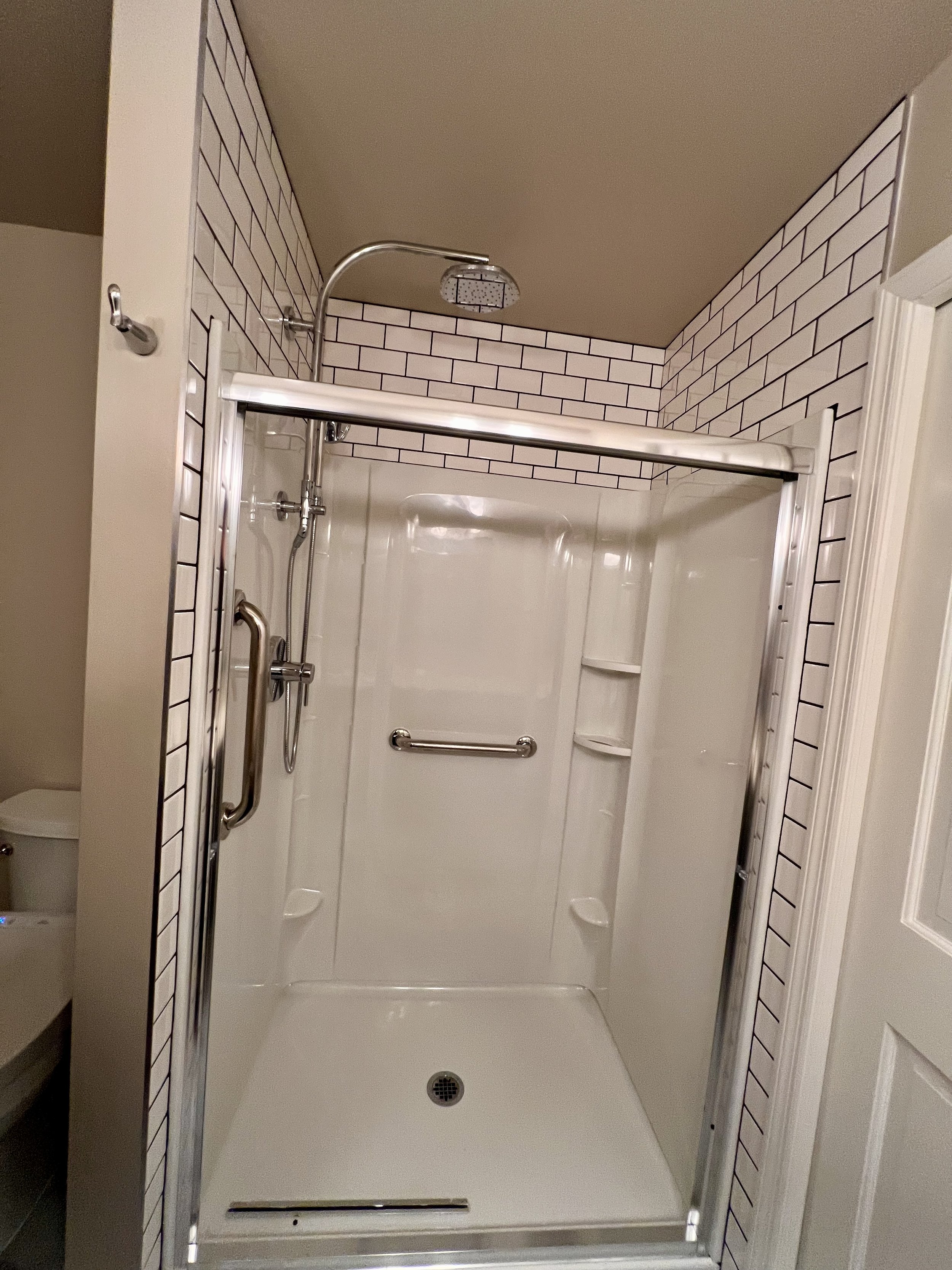 ACRYLIC SHOWER AND SURROUND WITH SUBWAYS TILE WALLS
