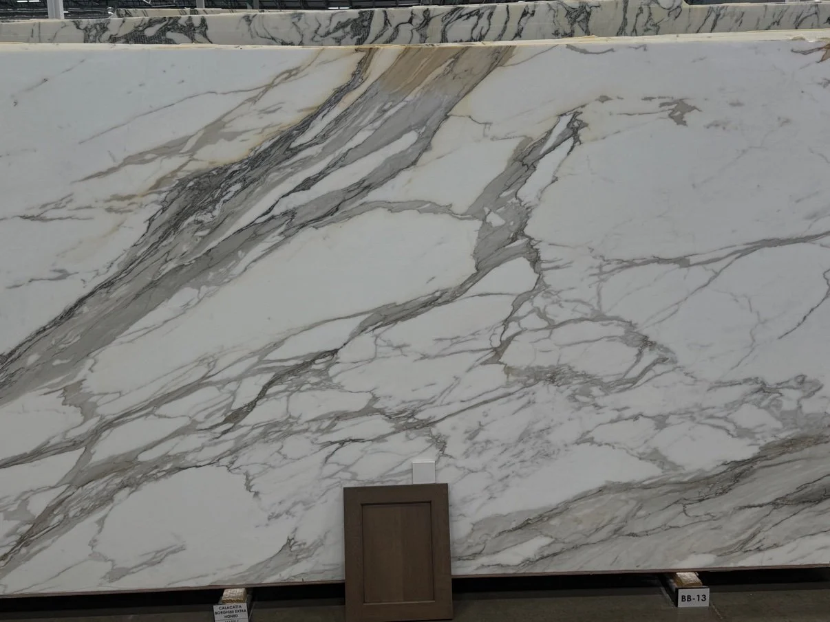 Choosing marble countertops in Casper, Wyoming — cabinet door sample against a Calacatta slab, Ever After Interiors