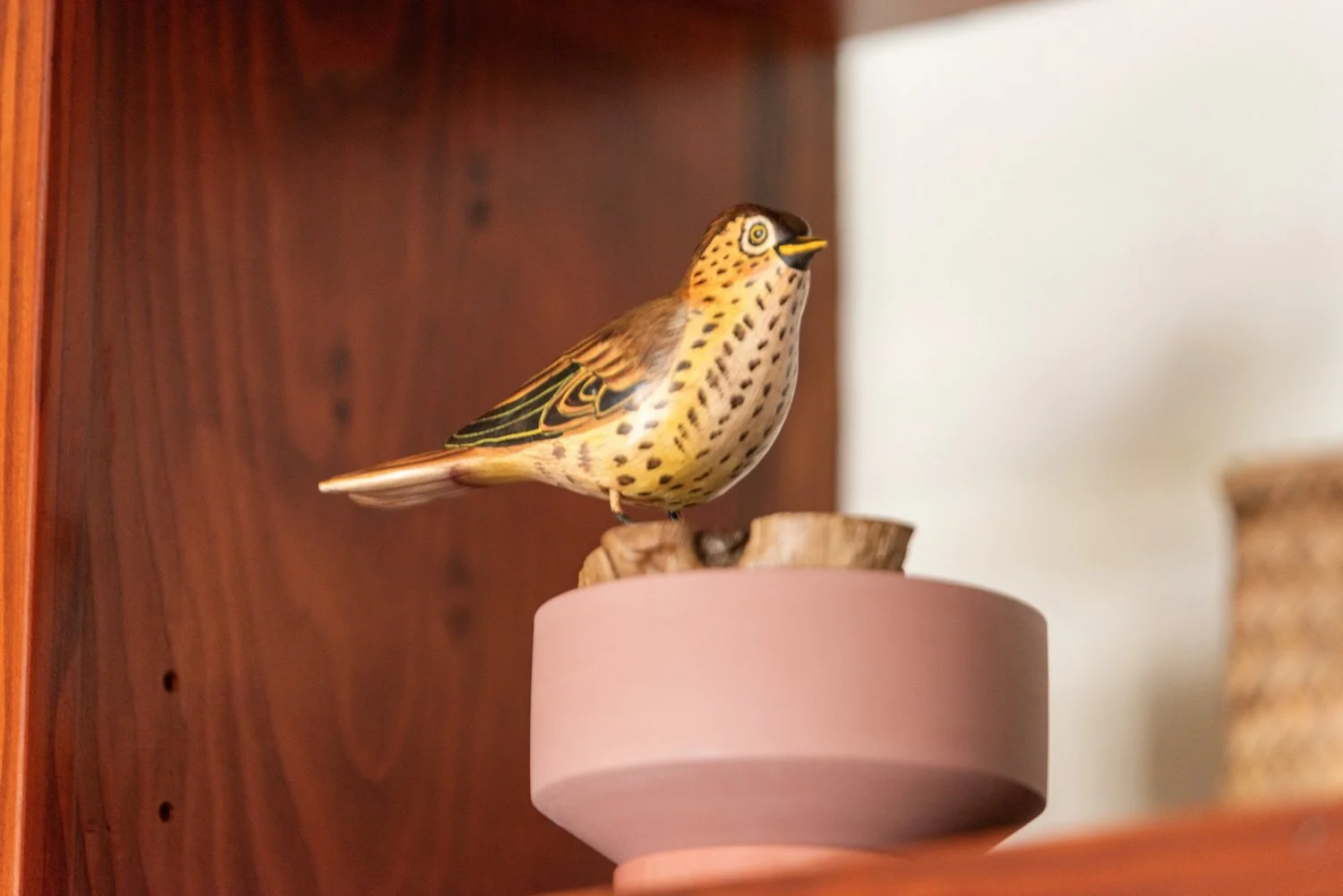 Photo by: Steven Dewall
A beautifully painted wooden bird figurine is playfully perched and animates this treasured collection of bird figurines with the joy of birdwatching.