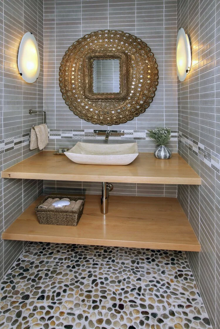 Photo by: Chas Metivier
Large multi-toned pebbles set the tone for this powder bathroom. Melding classic Moroccan influences with a contemporary strategy made for a delightfully balanced composition.