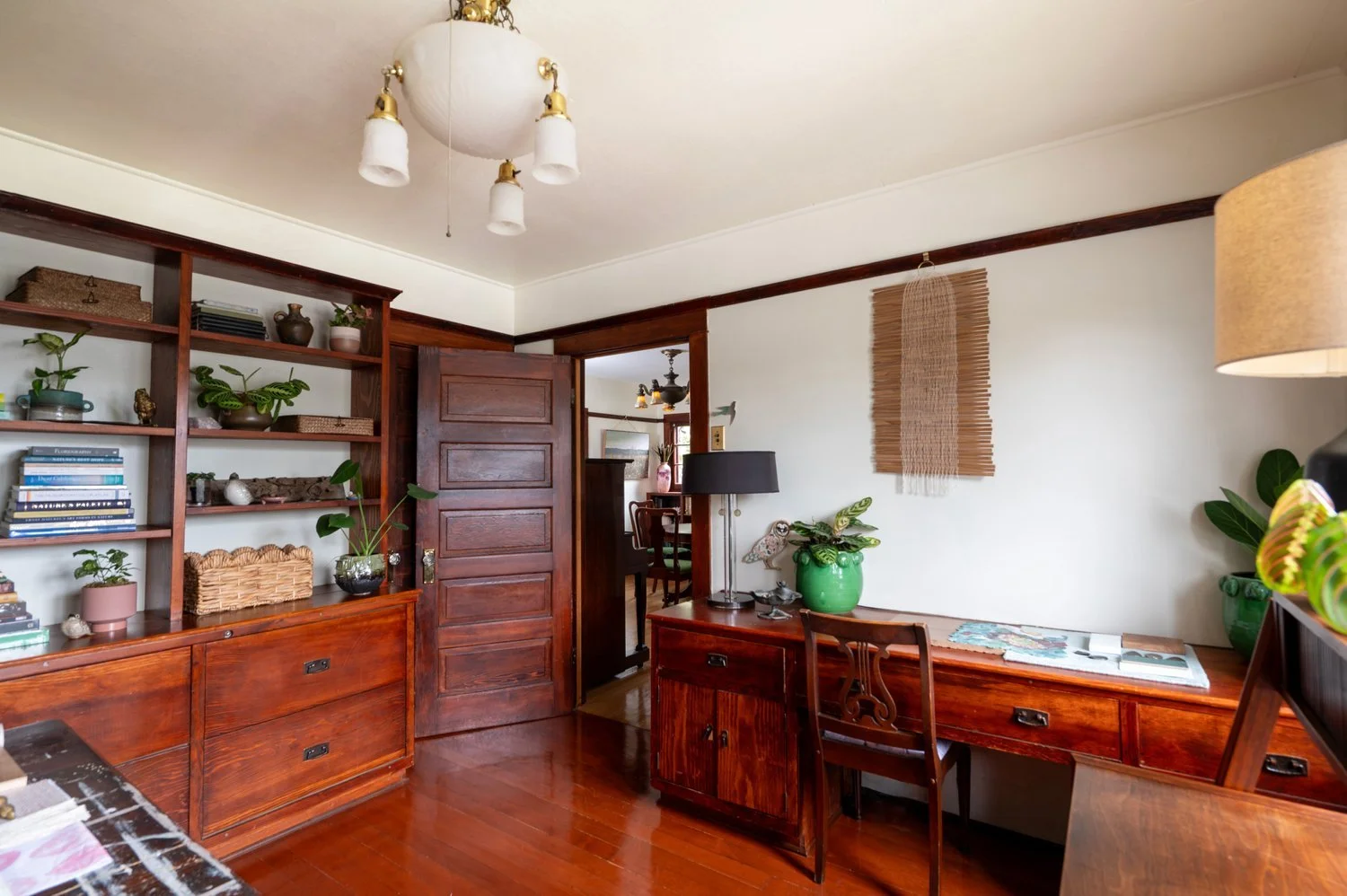 Photo by: Steven Dewall
The materiality of wood is a dominant design feature within this home office. An artwork by Aneesa Shami Zizzo weaves thin strips of wood with fiber to create a beautiful nature-inspired wall hanging over the built-in work des