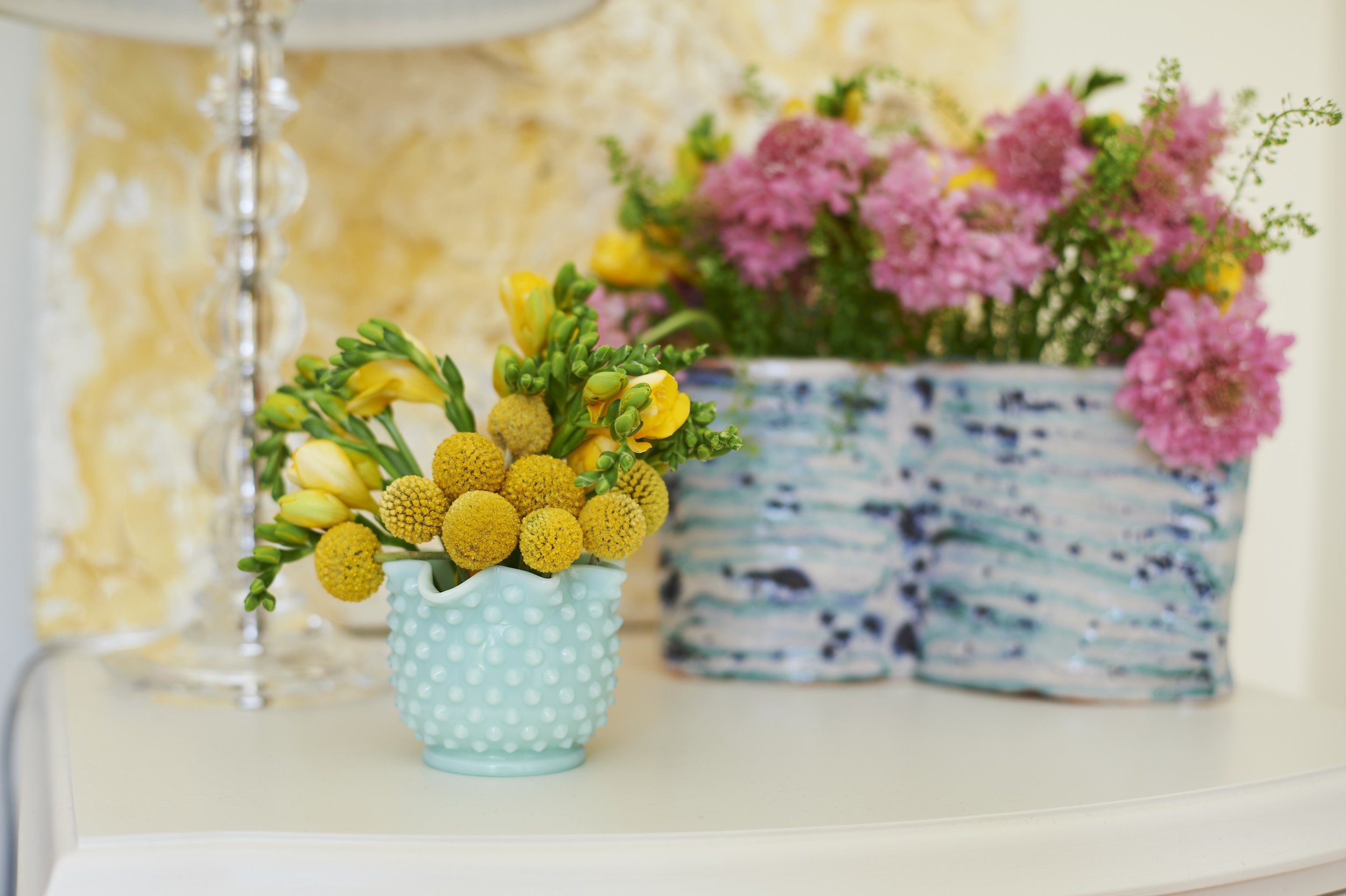 Photo by: Steven Dewall
A painting and ceramic vase by Renae Barnard pairs with vintage aqua hobnail glass. 