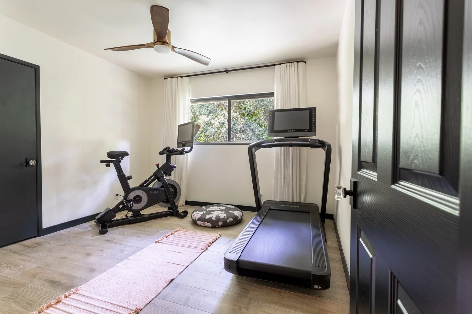 Photo by: Ace Misiunas
The home gym features organic linen curtains that frame windows looking out on the serene woodland.