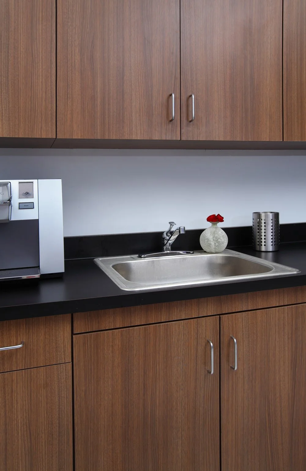 Photo by: Chas Metivier
The staff break room is outfitted with Neo Walnut Velvet laminate finished cabinets and a black, matte laminate counter from Wilson Art. 