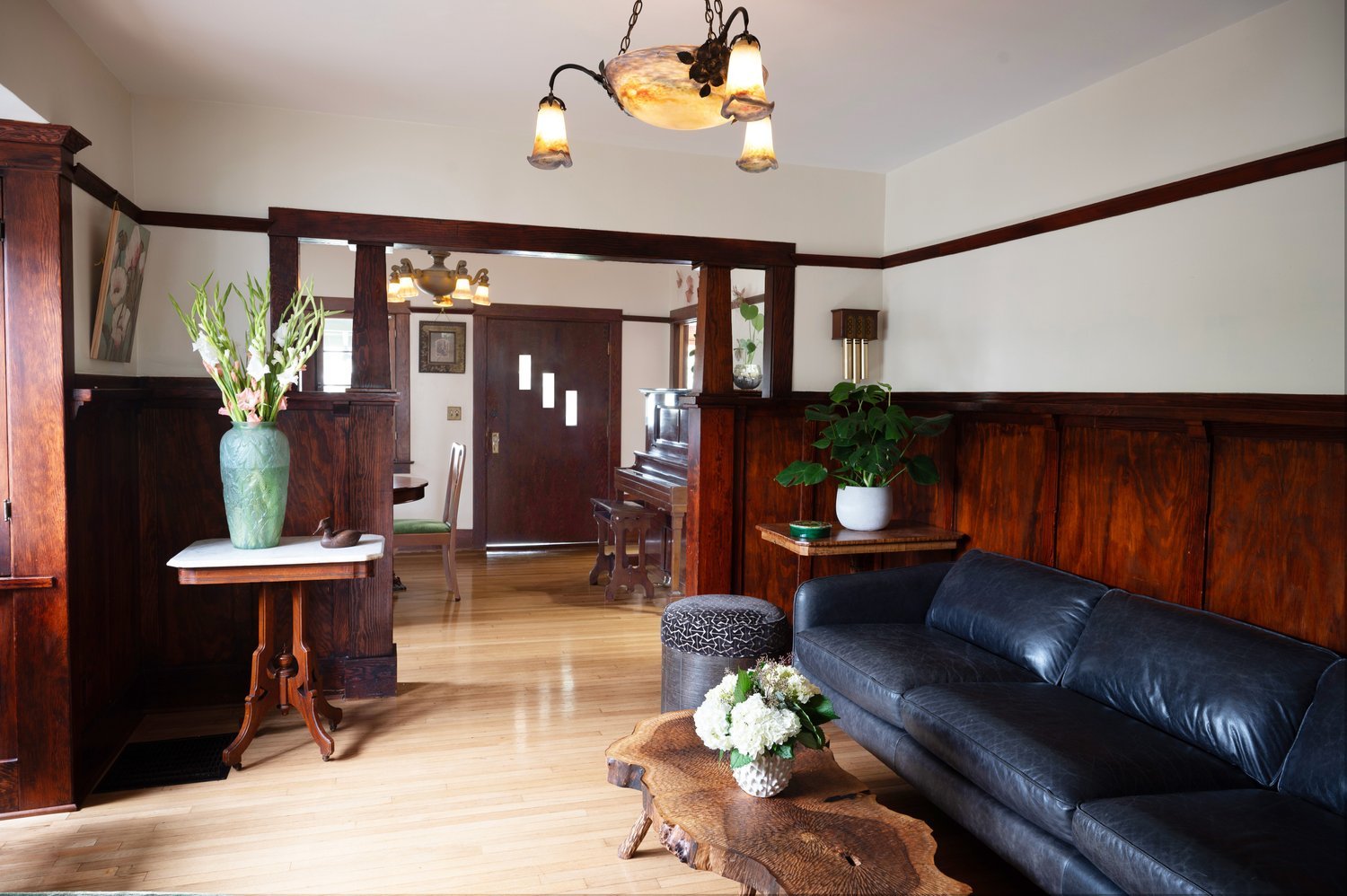 Photo by: Steven Dewall
Wood flooring, wainscotting, and built-in cabinetry swath the living room in the beauty of natural woodgrain, creating an indoor-outdoor connection through biophilic design.