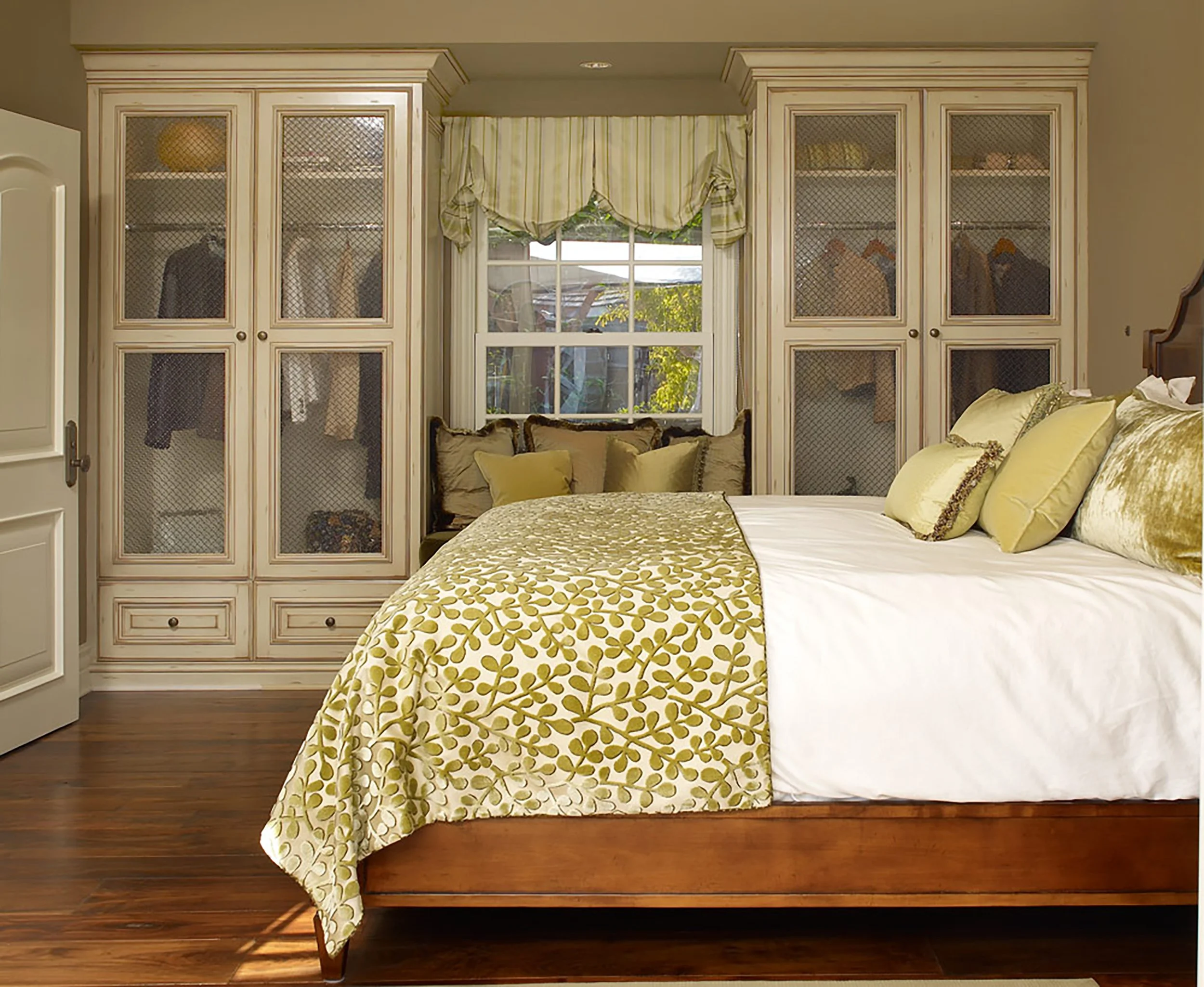 Photo by: Scott Van Dyke
Antiqued white cabinetry creates a cozy reading nook between two custom closets outfitted with Flemish glass and antique bronze detailing.