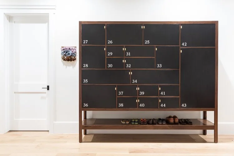Cabinet with varied door sizes, each labeled with hand painted numbers.