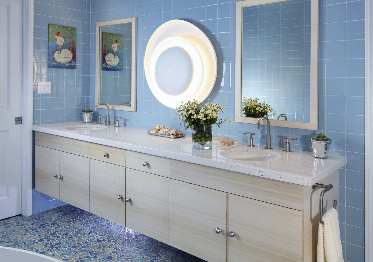 Photo by: Chas Metivier
A sea of blue ceramic tile paired with organic form glass floor tiles and an orb-like wall sconce create a fresh aesthetic for a child’s bathroom.