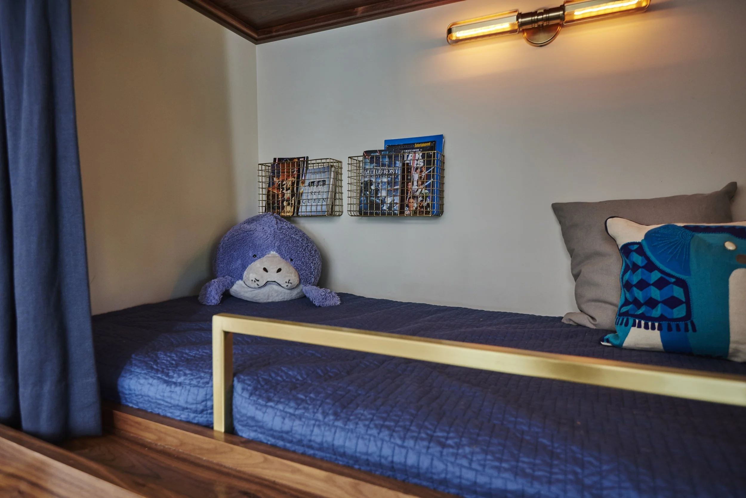 Photo by: Steven Dewall
Each bunk bed has a pair of blue linen draperies lined with black-out lining. The draperies fit neatly into custom grooves in the bunks so that everything stays just where it belongs. 