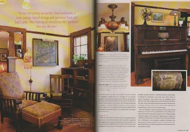 A two-page interior spread of a magazine showing a cozy living room with vintage furniture, artwork, a wooden piano, and decorative items, along with text describing the scene.