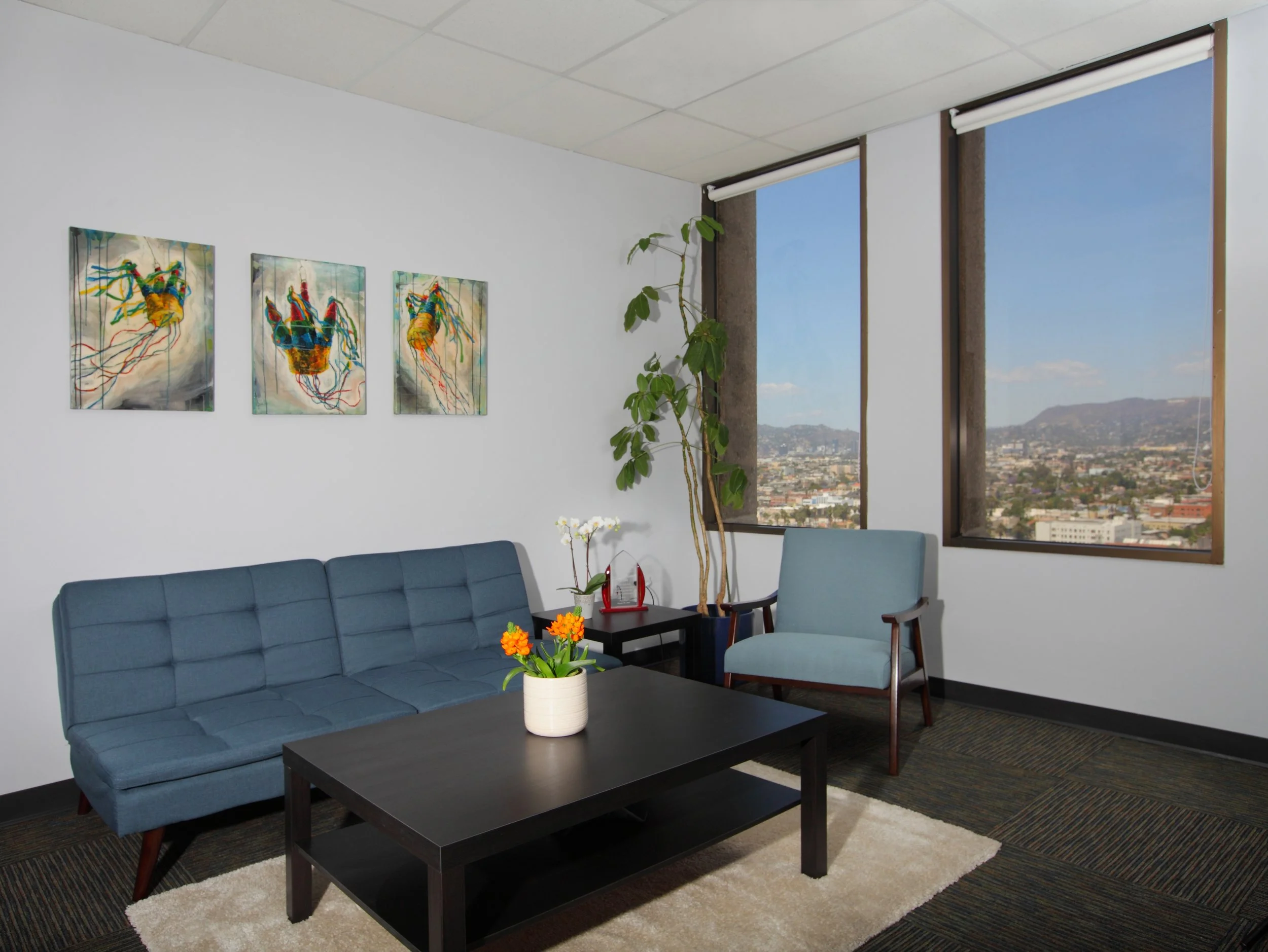 Photo by: Chas Metivier
Pinata Triptych by artist Anna Stump hangs above a vintage seating arrangement in the executive director’s office. 