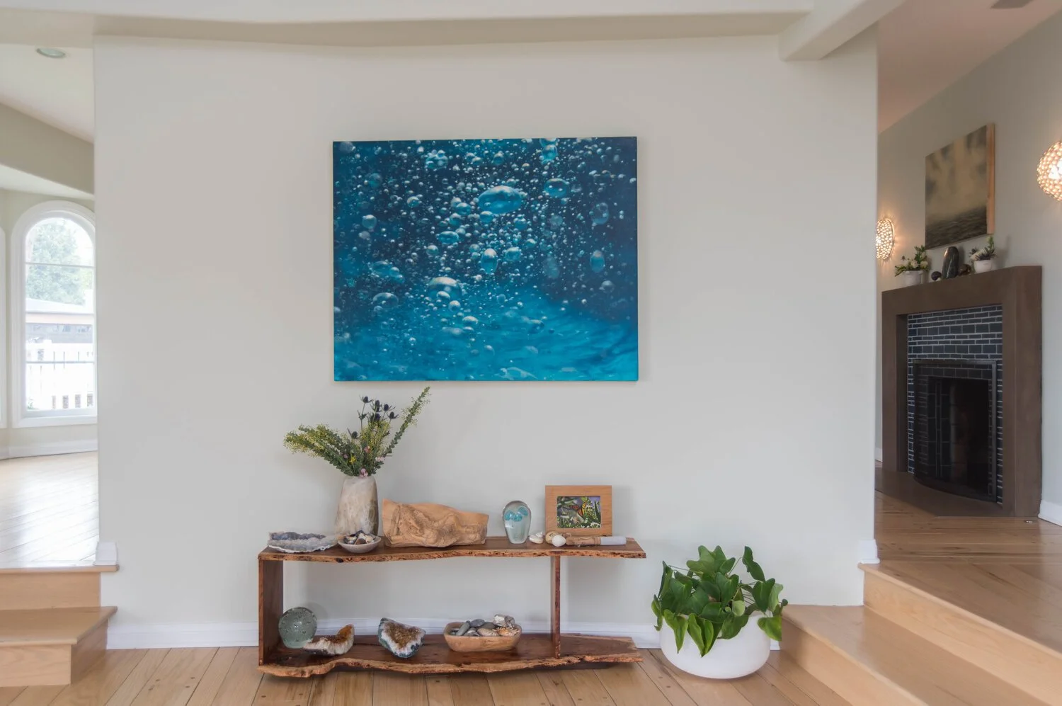 Photo by: Steven Dewall
A handmade table by a local artisan, anchors the space between the living room and dining room. Painting by Eric Zener.