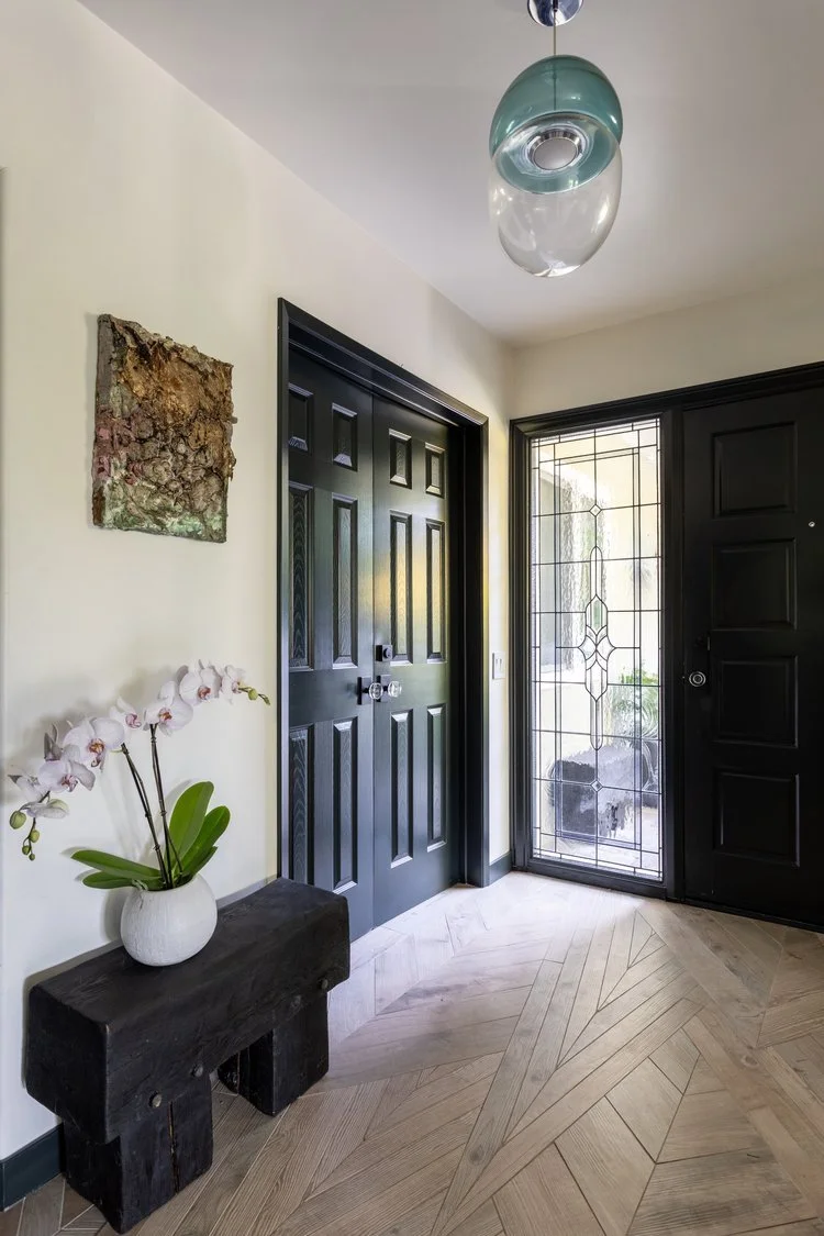Photo by: Ace Misiunas
This entryway features a one-of-a-kind mosaic floor custom designed by Sarah Barnard, where angled strips of wood-like porcelain tiles were meticulously placed to resemble the mountain landscape outside. An artisan-made bench a