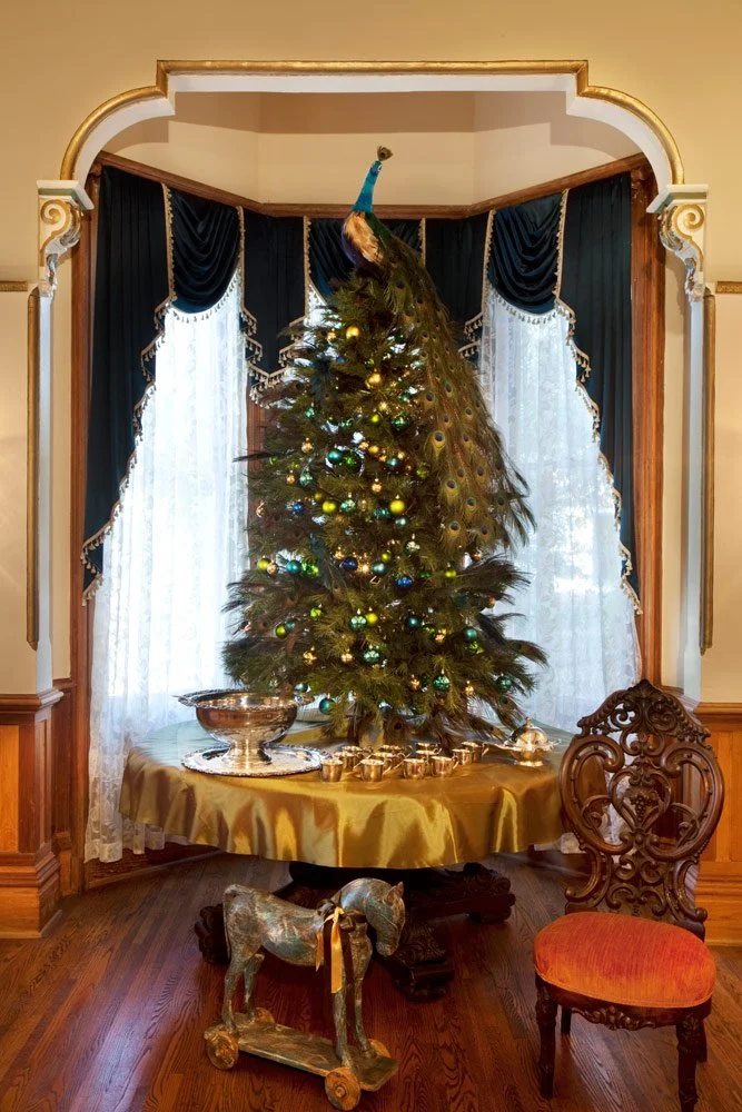 Photo by: Brad Nicol
A faux peacock perches atop a holiday tree decked in teal, lime, and champagne glass balls.