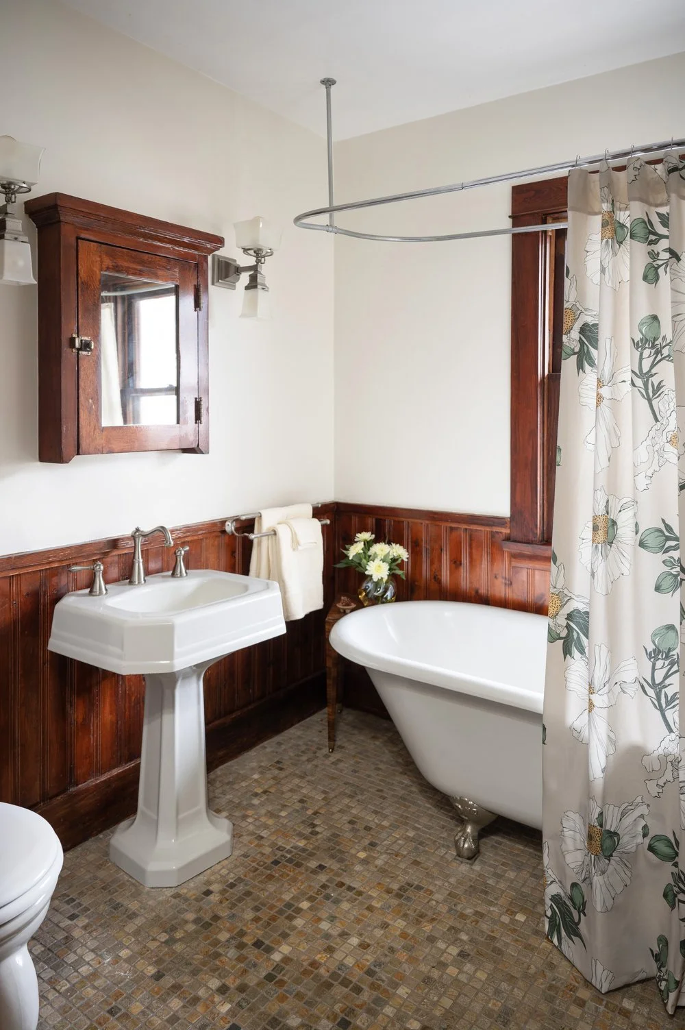 Photo by: Steven Dewall
Natural materials are incorporated into this bathroom through local Californian slate mosaic flooring, wood cabinetry, and wainscotting. This stone's nature-inspired brown, white, and grey palette harmonizes with the warmth of