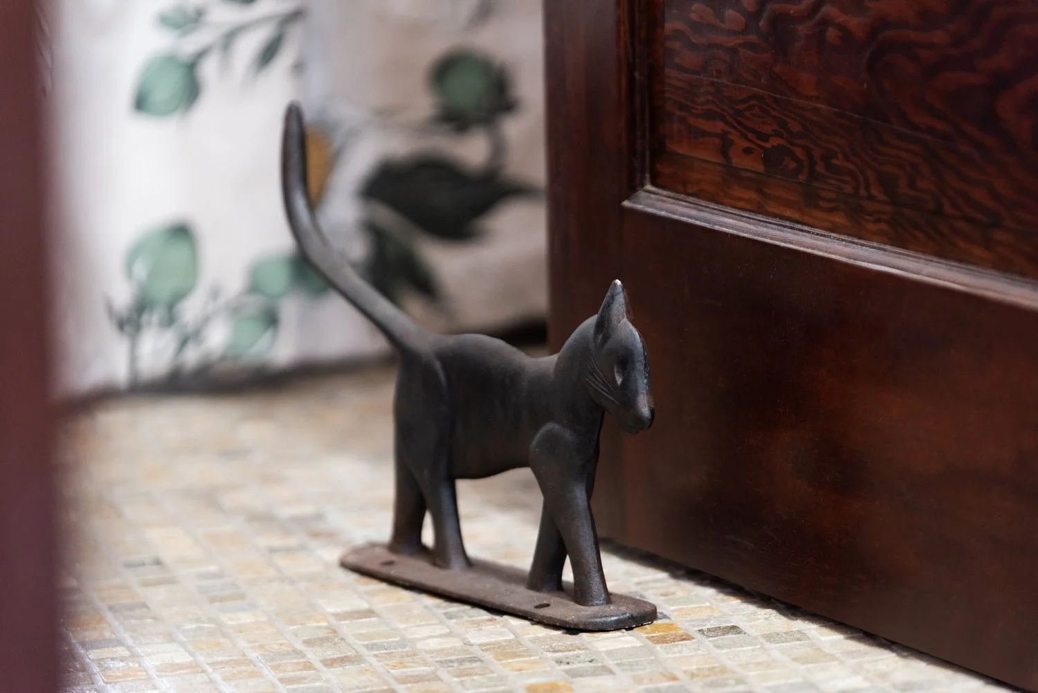 Photo by: Steven Dewall
An antique cast iron boot scraper shaped like a cat is playfully repurposed to serve as a doorstop.
