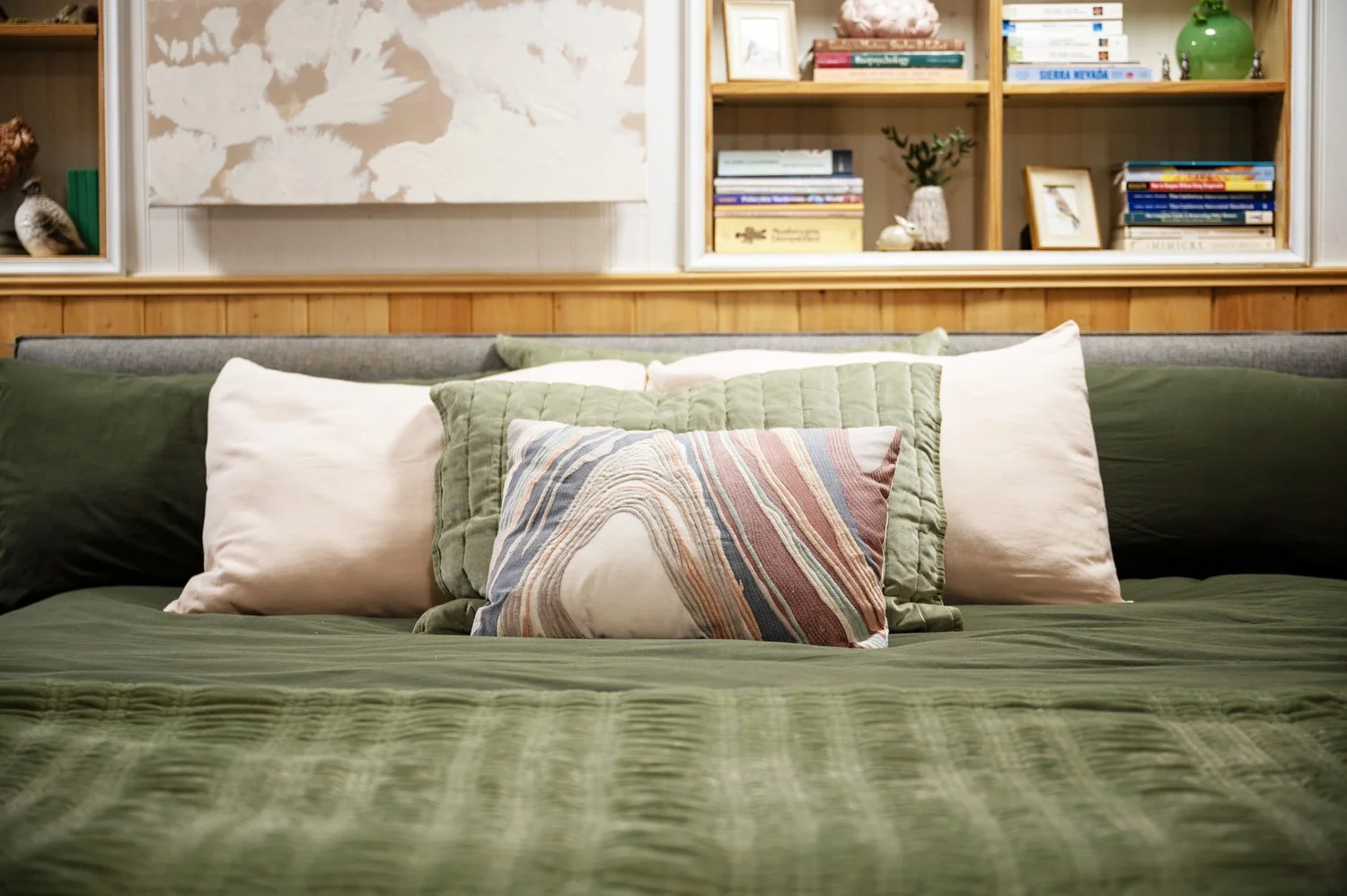 Photo by: Steven Dewall
This nature-inspired palette of green, earthy pink, and grey works with the warm wood tones of the room to create a tangible connection with the outside environment through biophilic design.