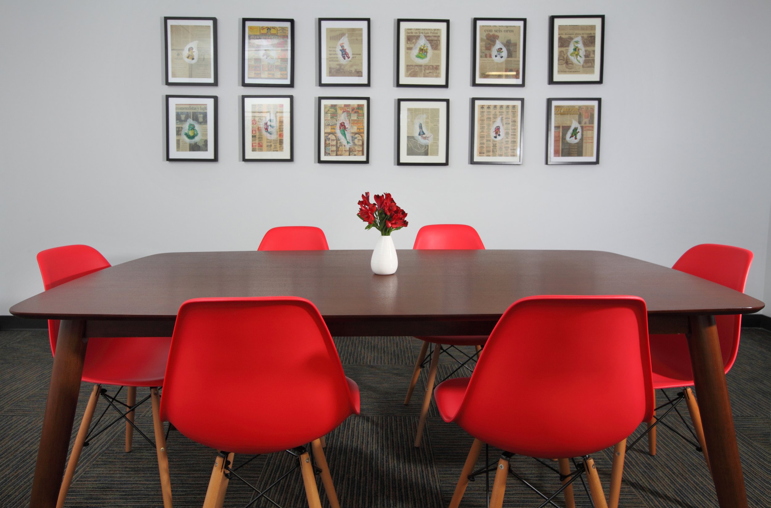 Photo by: Chas Metivier
A set of eight framed gouache paintings on newsprint by artist Anna Stump titled Pinata Studies pairs well with the plastic shell chairs. 