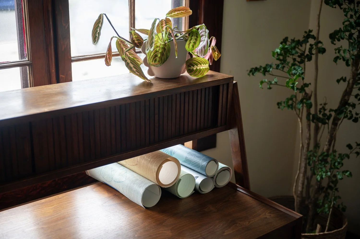 Photo by: Steven Dewall
A 1960s midcentury bi-level walnut tambour door desk made from Rosewood harmonizes with the many wood finishes throughout the room.