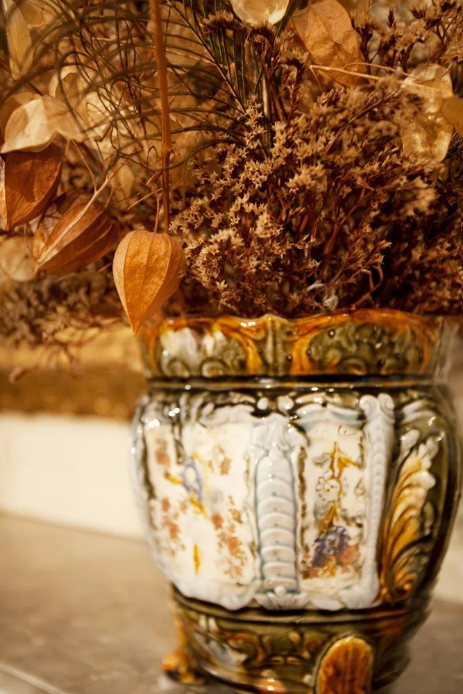 Photo by: Brad Nicol
Antique hand-glazed pottery holds an assortment of dried botanicals on the original marble mantel.