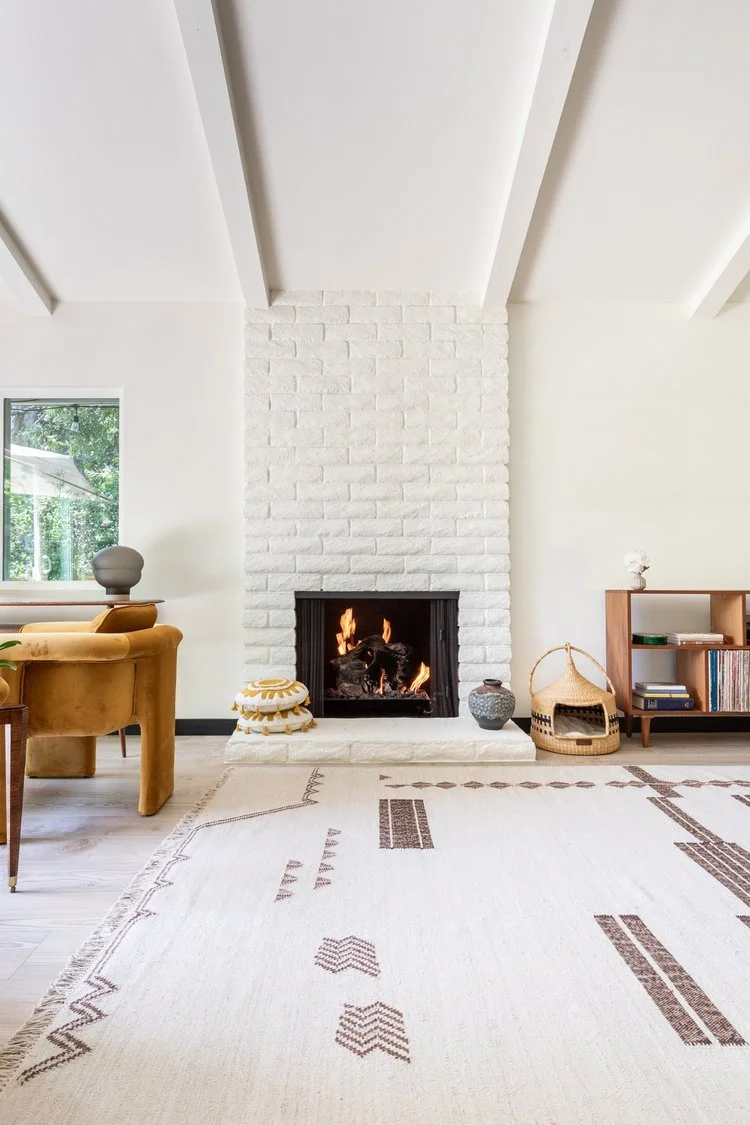 Photo by: Ace Misiunas
The brick fireplace was painted white, integrating it into the light and airy feel of the room. A rustic hearth surface was created in plaster, reminiscent of the organic patterns in the dry earth of a desert landscape.