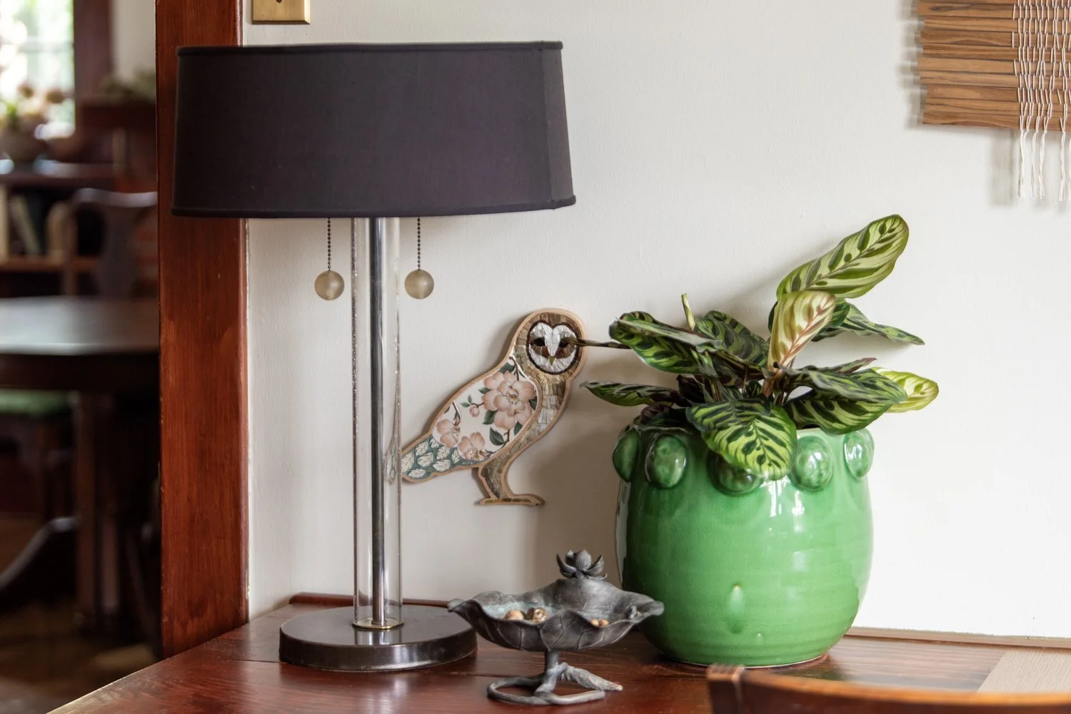 Photo by: Steven Dewall
A Japanese bronze lilypad dish from the 1940s holds a collection of acorns next to a mosaic owl made from decorative tile.
