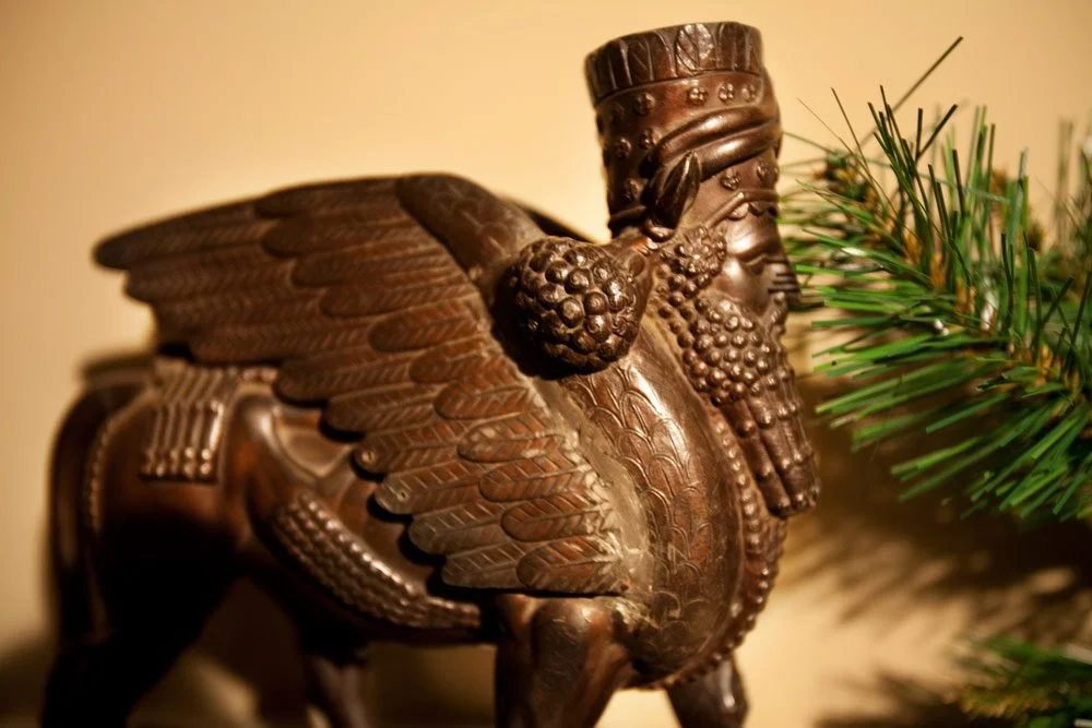Photo by: Brad Nicol
A pair of antique bronze Lamassu figurines nestles among winter greens.