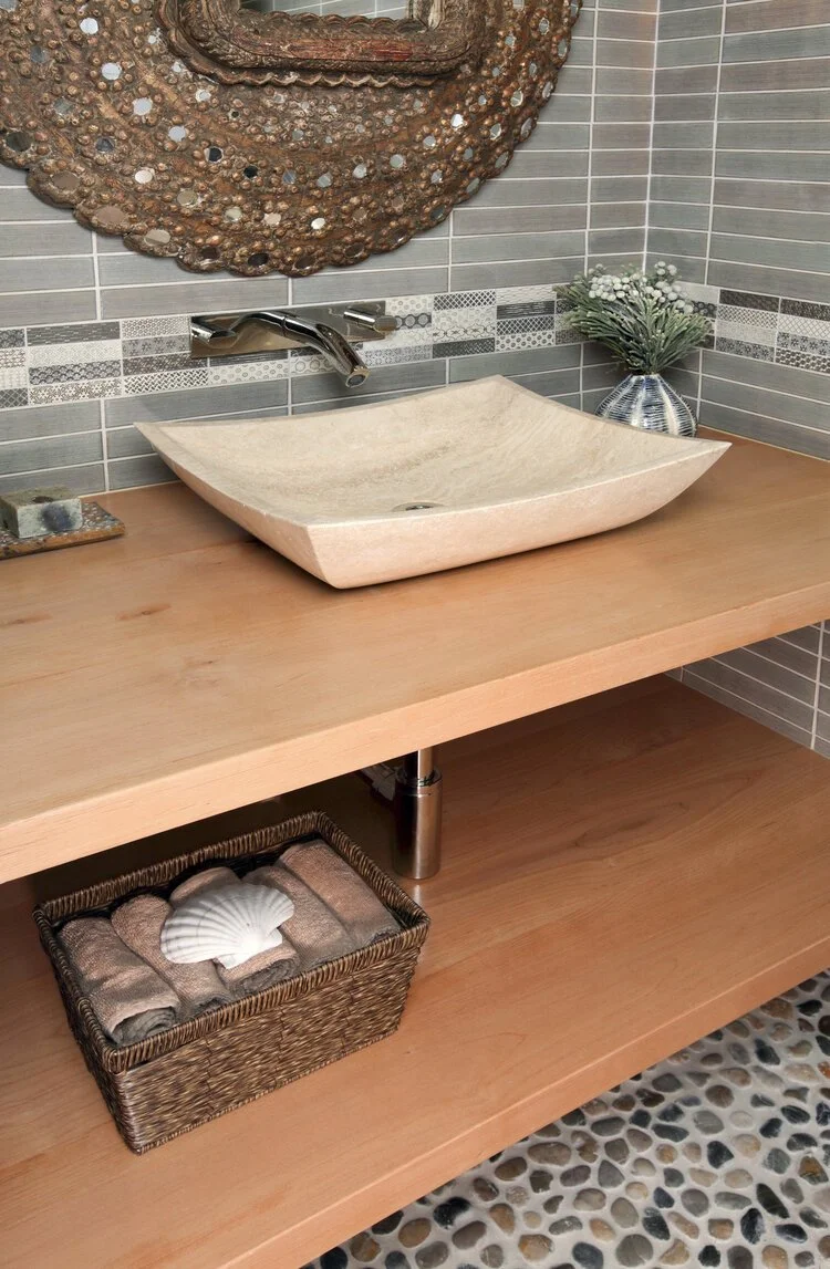 Photo by: Chas Metivier
A hand-carved stone sink sits atop custom maple shelving in this jewel box of a powder bathroom.