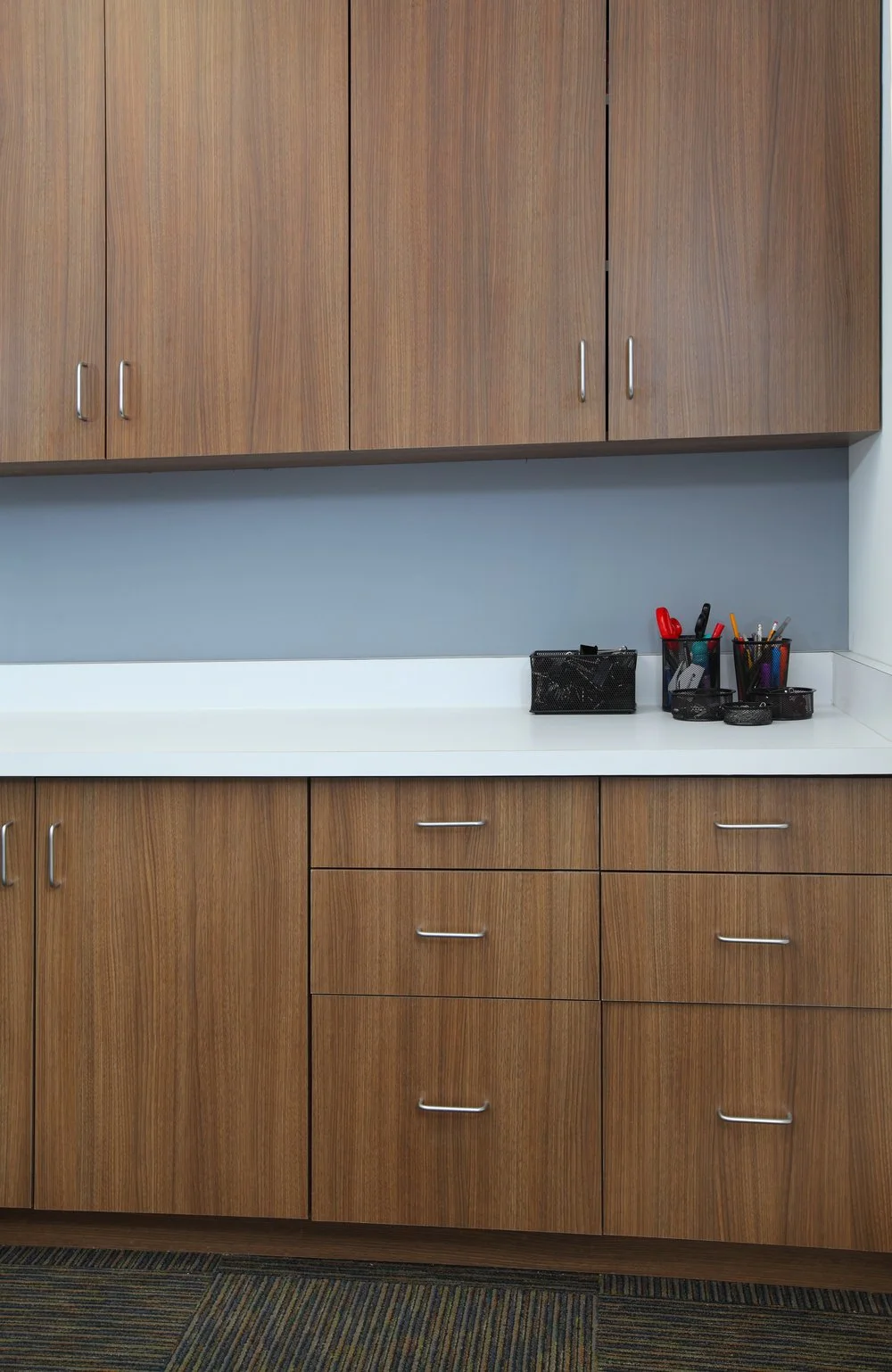 Photo by: Chas Metivier
Neo-walnut velvet laminate cabinets with white designer laminate counters installed in the copy room provide accessible storage."