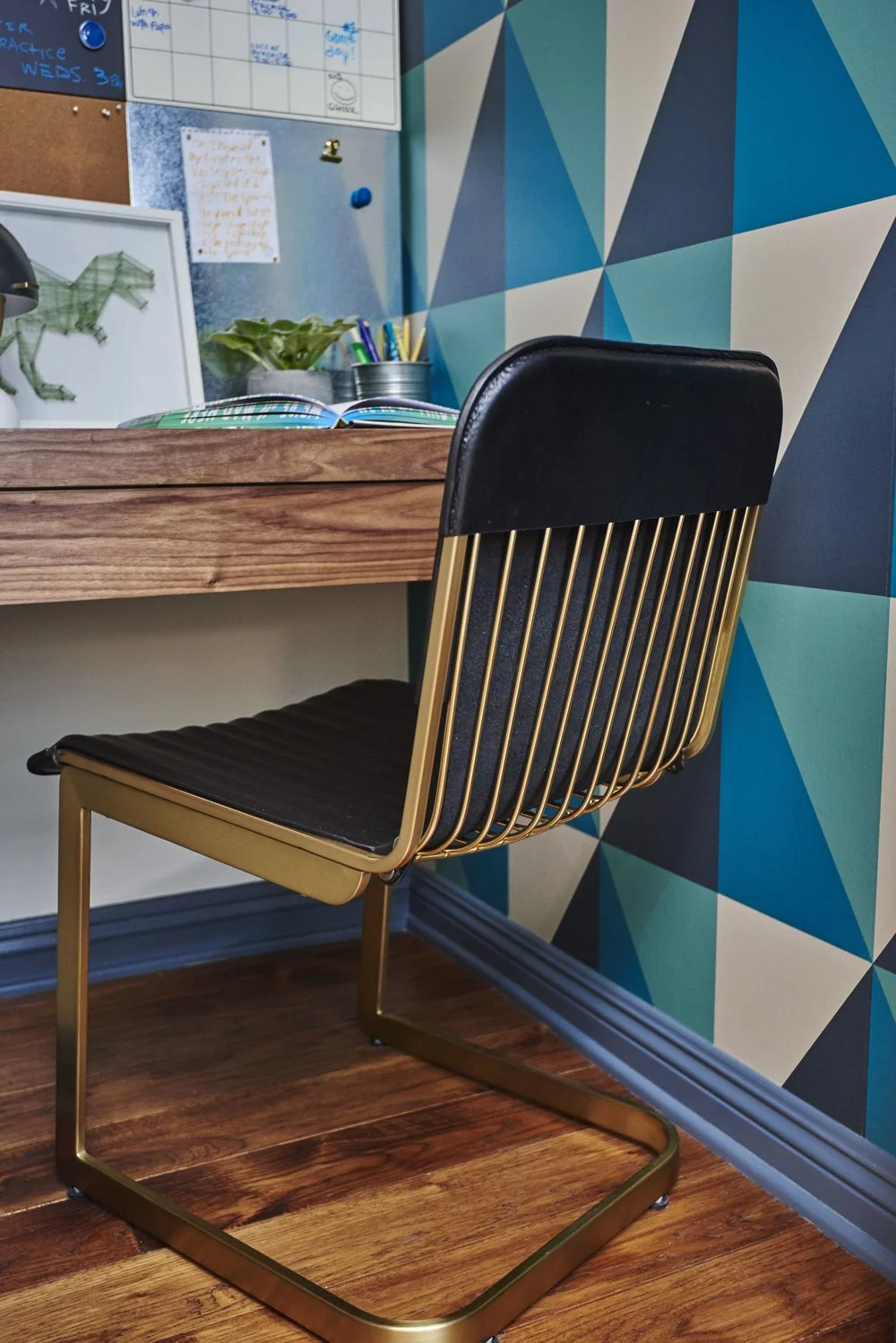 Photo by: Steven Dewall
Cantilevered desk chairs in antique brass and black leather. 