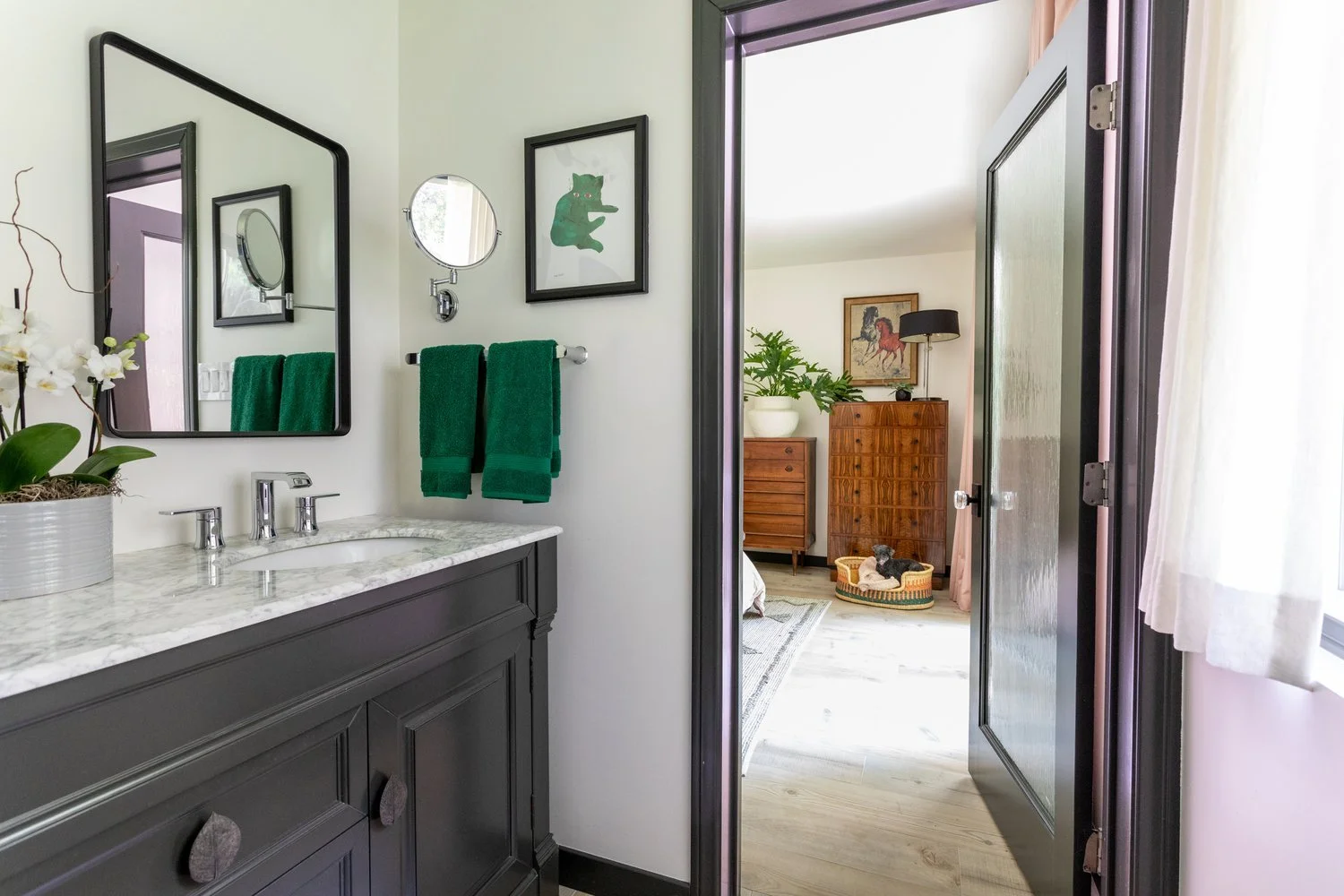 Photo by: Ace Misiunas
White linen curtains frame the bathroom window, and a pollinator house is installed outside.