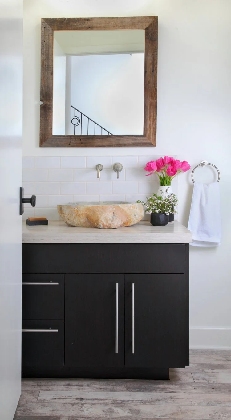 Photo by: Chas Metivier
A grey river rock vessel sink pairs with honed stone counters and crackled ceramic backsplash tiles.