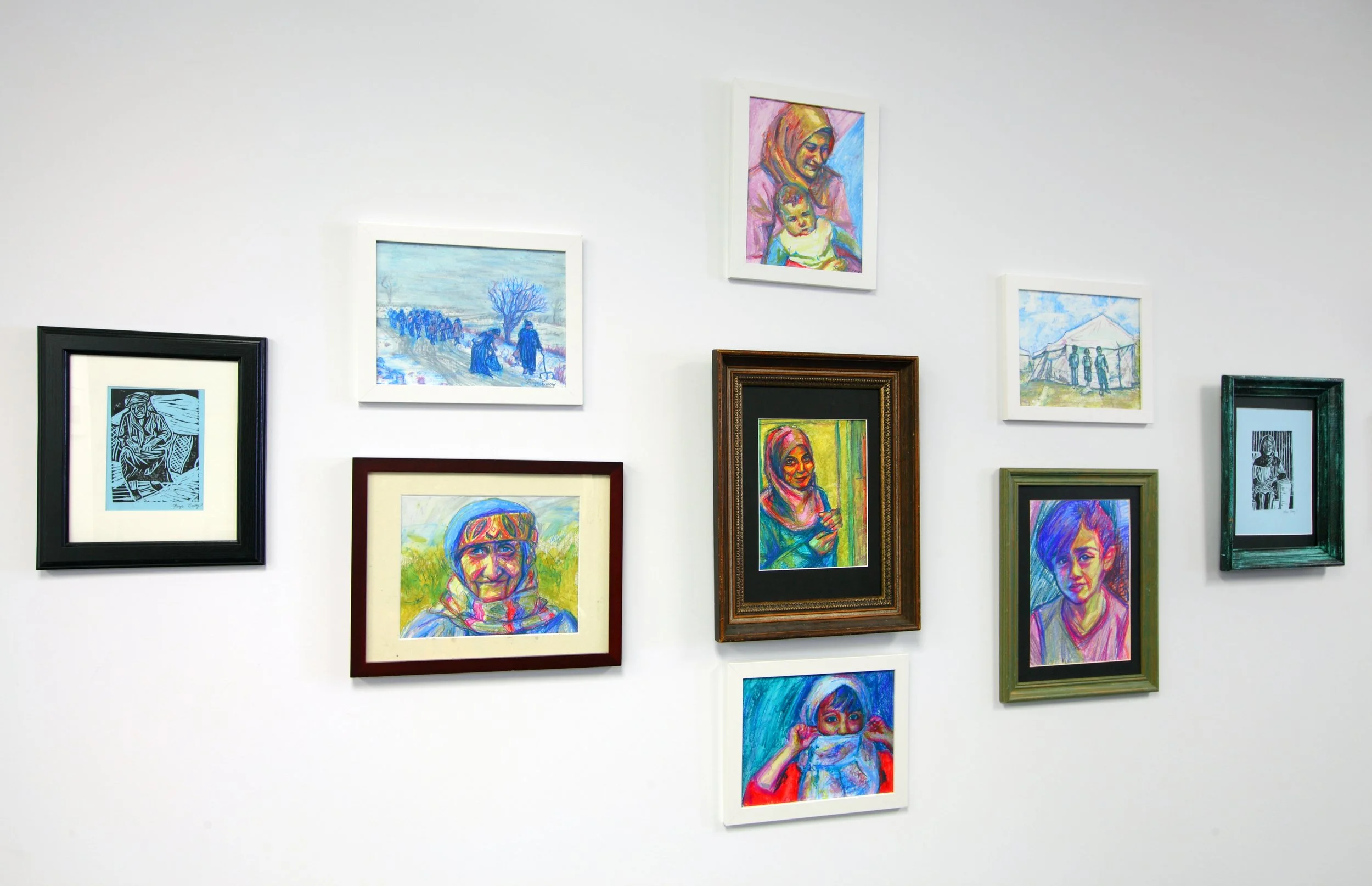 Photo by: Chas Metivier
This wall features the Defend and Advance exhibition curated by Renae Barnard. Proceeds from the colorful framed drawings by Paige Emery benefit Syrian refugees.