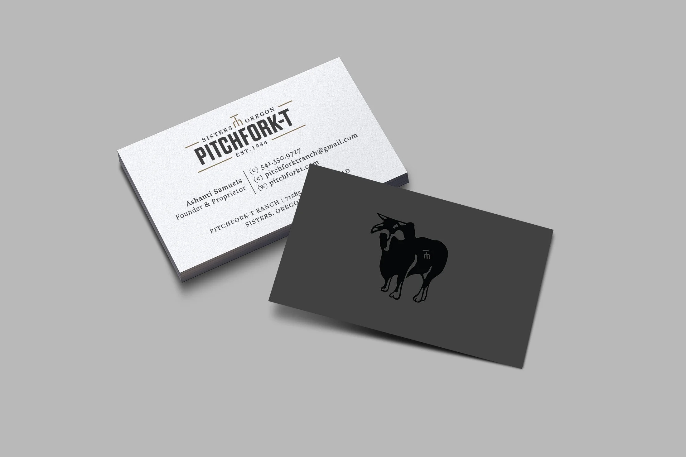 Stack of business cards for Pitchfork, an Oregon-based company, with a black pitchfork logo on a dark card and contact information on a white card.