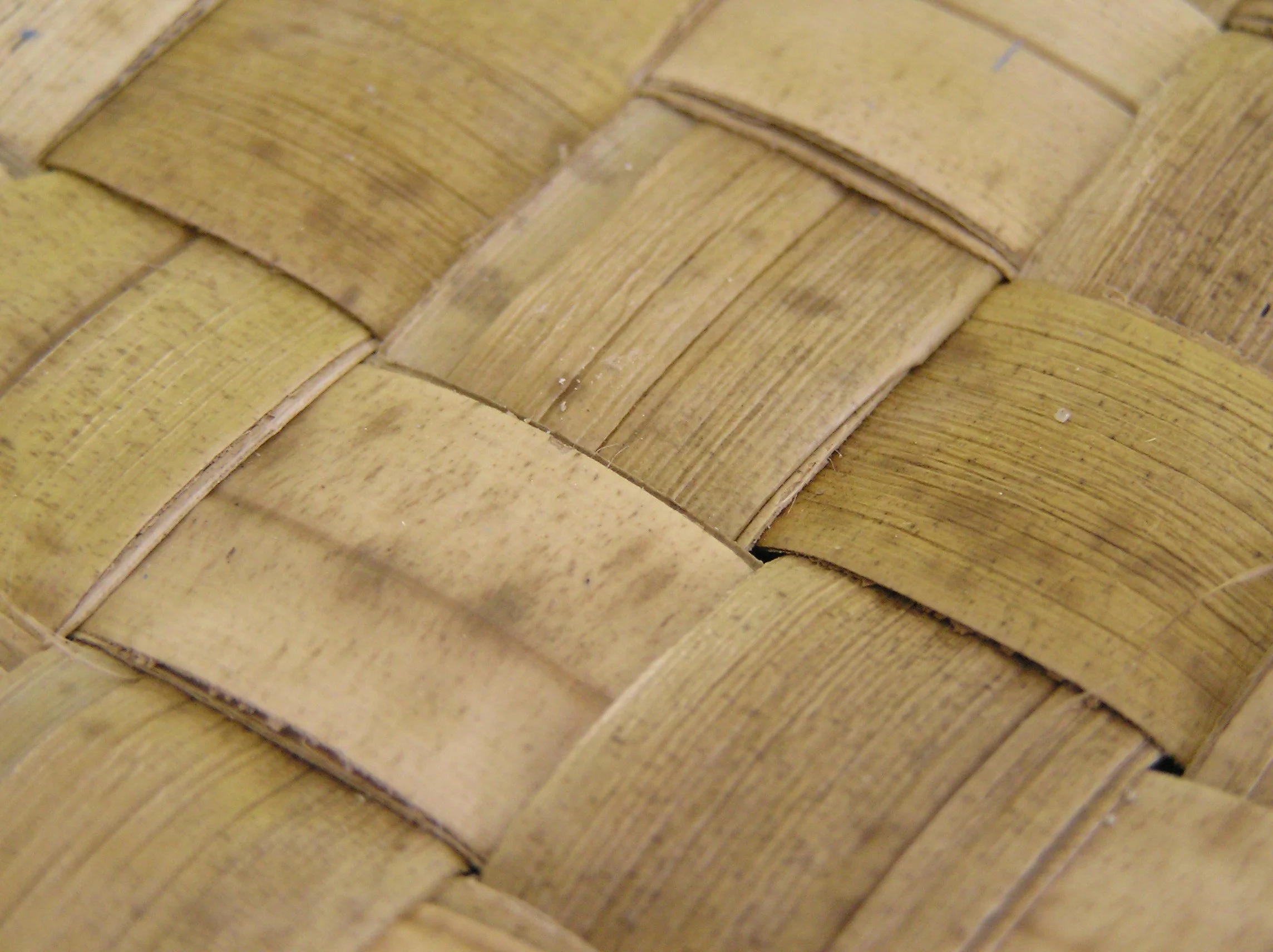 Close-up of woven strips in a pandanus sitting mat - colors are beige and brown.