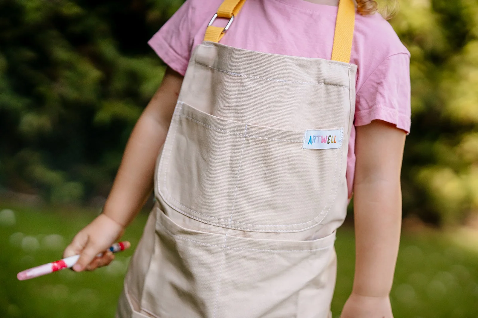 Close-up of the ARTWELL kids apron pocket and adjustable straps.