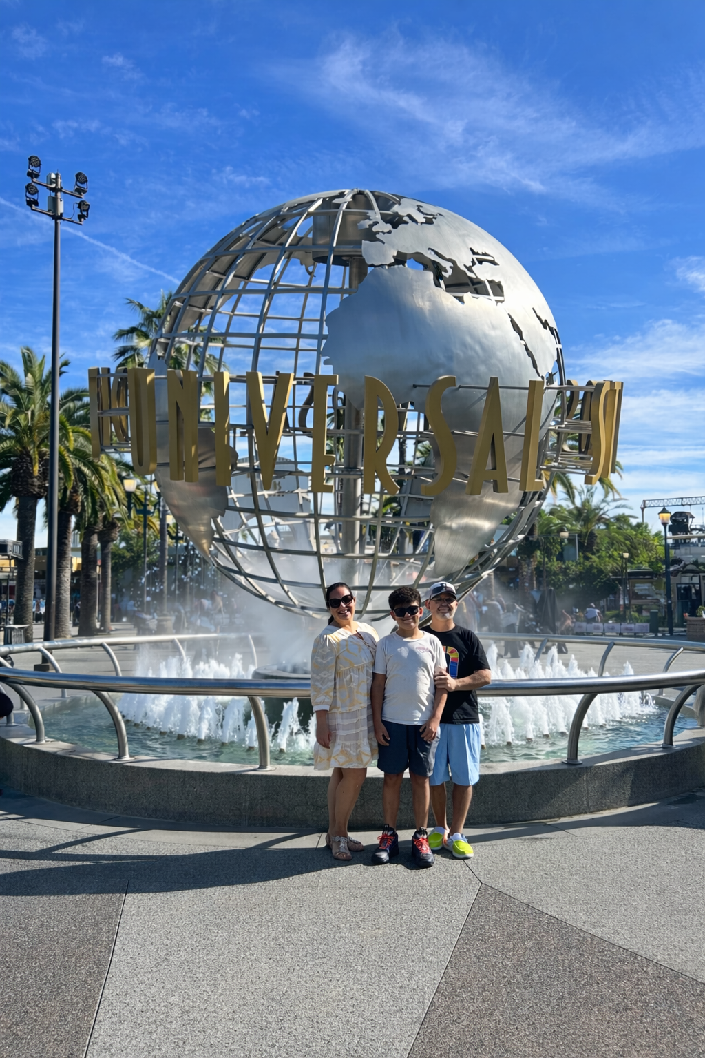 family smiling in front of universal studios globe representing life success and personal journey