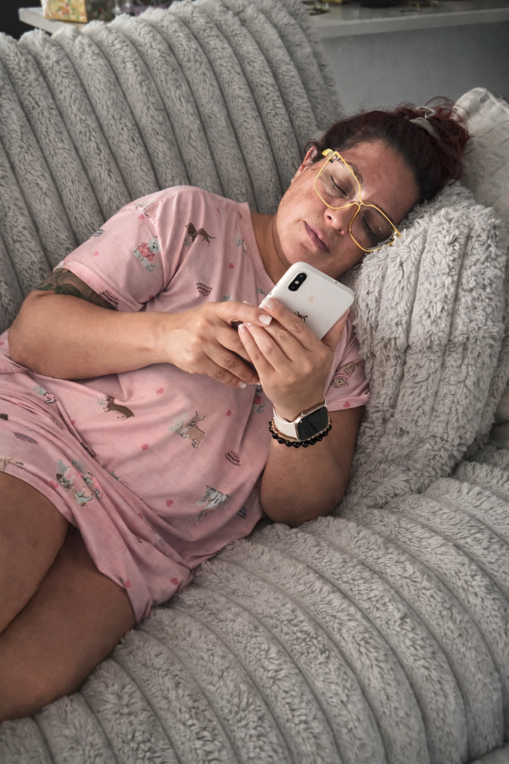 Woman holding phone while sitting in a quiet moment, representing emotional burnout, overwhelm, and constant stress