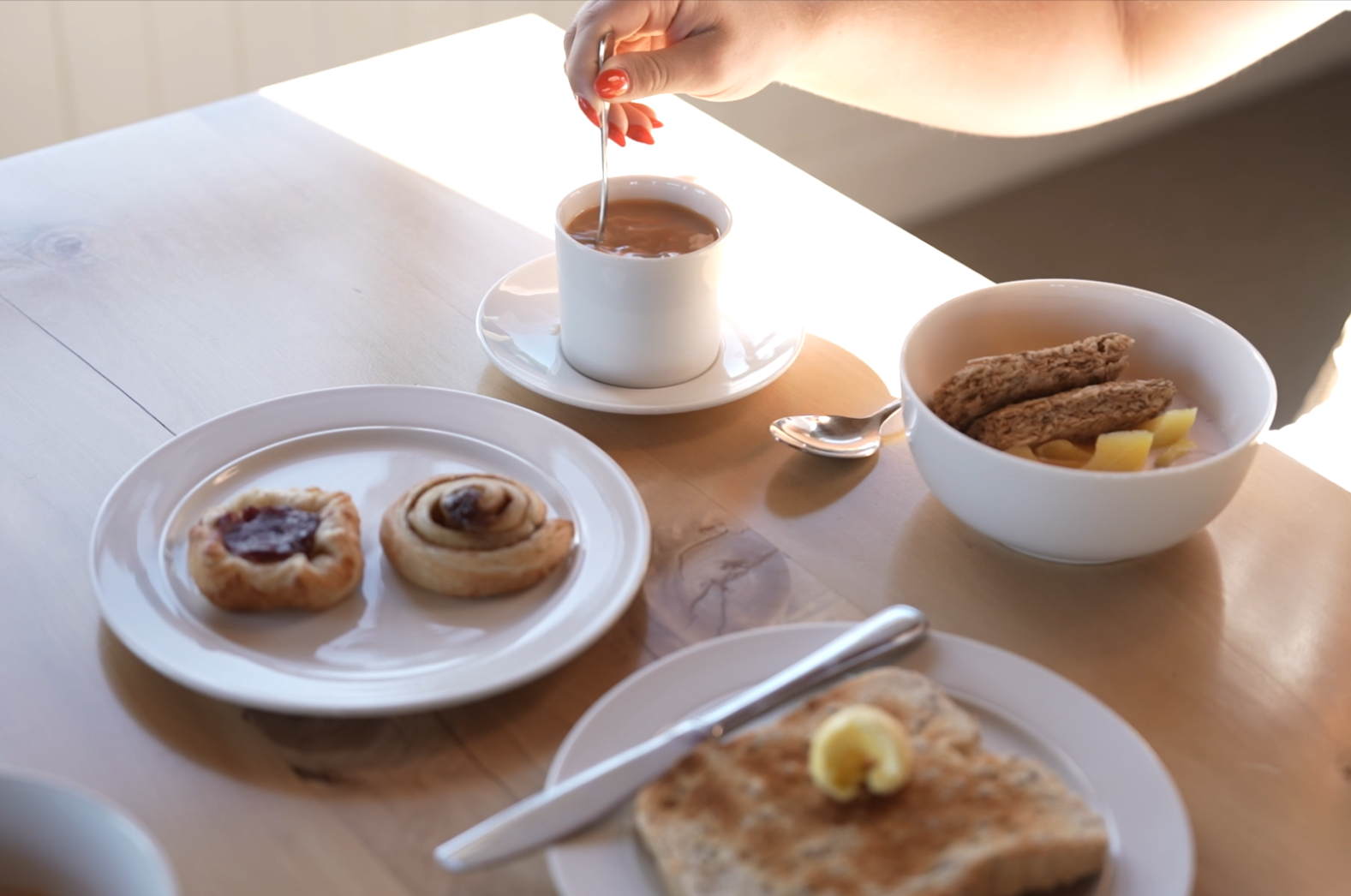 Continental breakfast at Lake Brunner Eco Lodge with toast, pastries, cereal and a hot drink in the morning light.