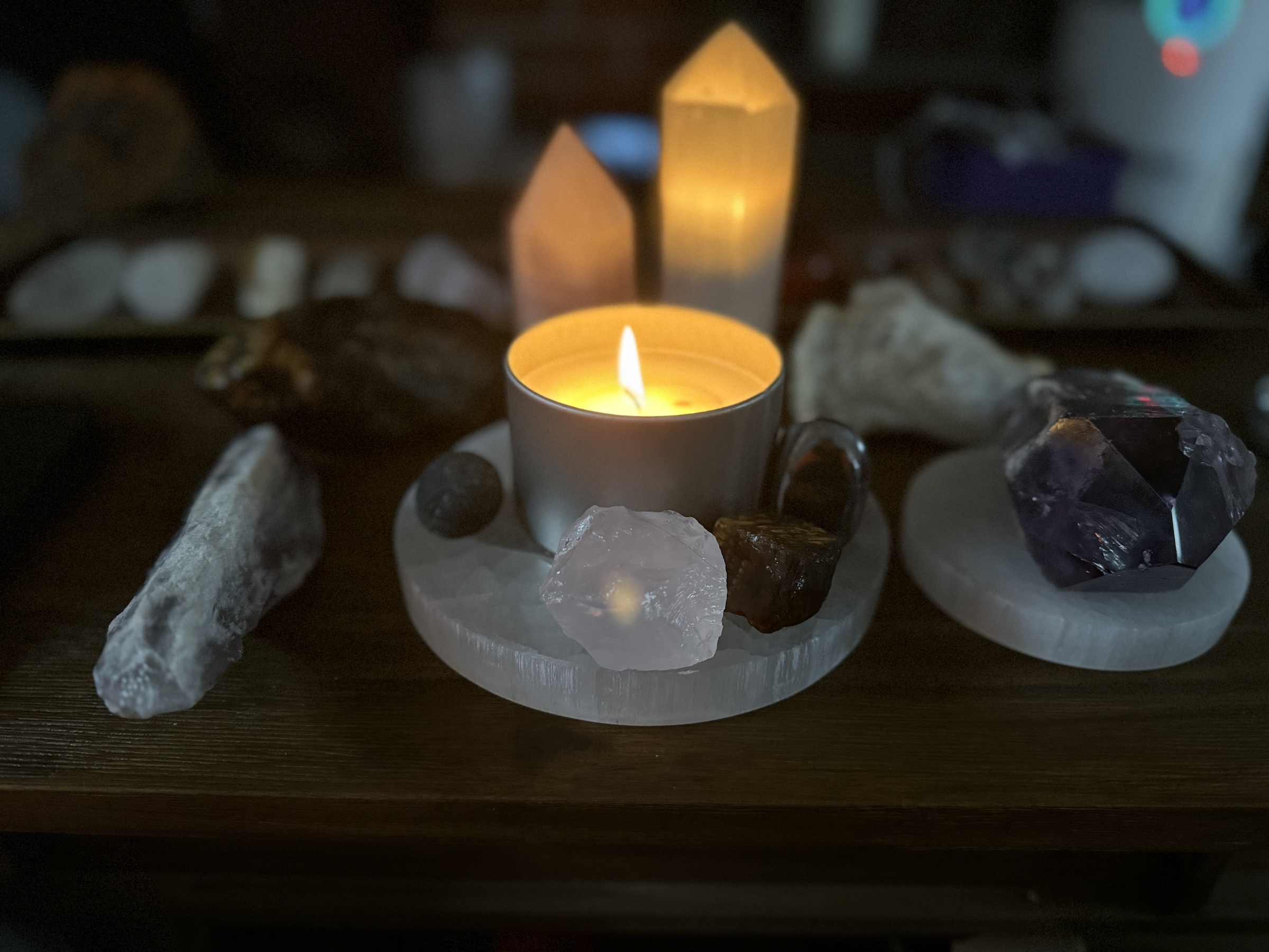Handmade sage and pine candle surrounded by crystals