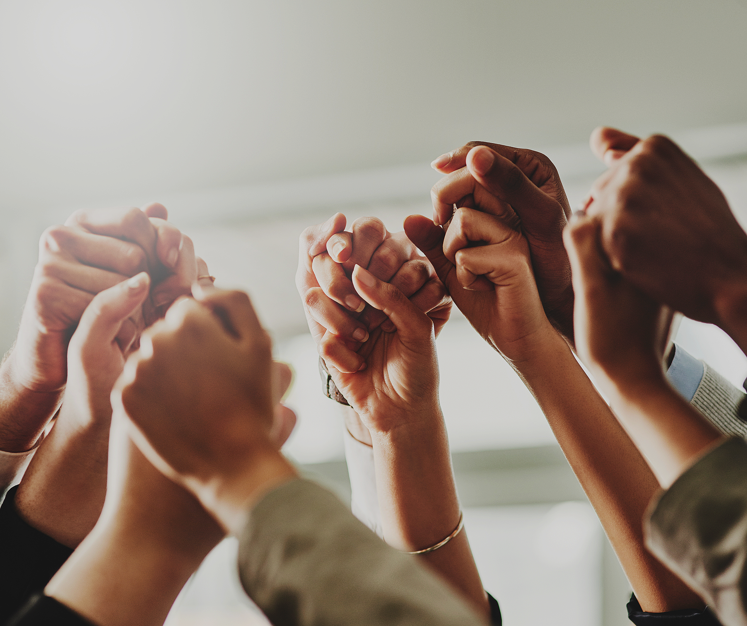 Mehrere Hände, die zu einem Gruppenhandshake zusammenkommen.