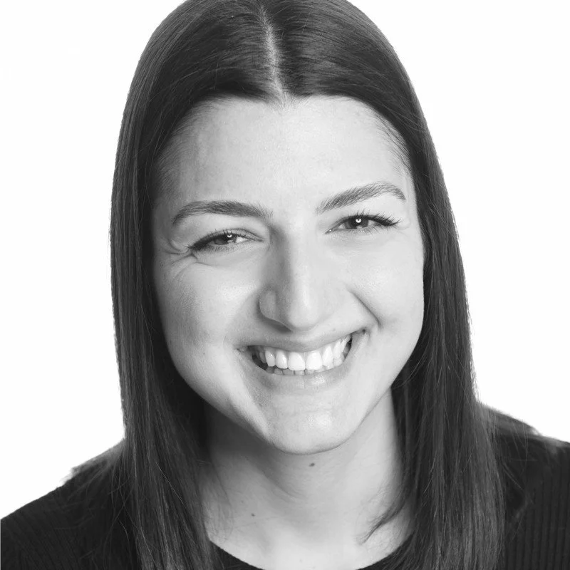 Lächelnde junge Frau mit dunklen, geraden Haaren in Schwarz-Weiß-Foto