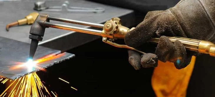 Welder wearing gloves welding metal with sparks flying