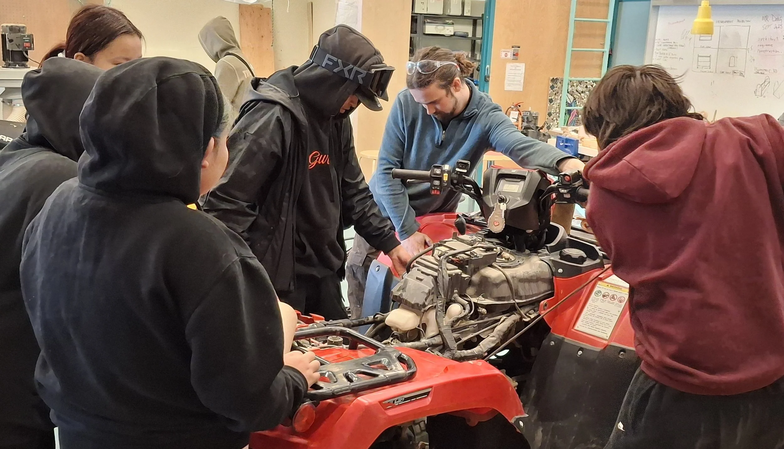 Learners doing work on a partially assembled 4-wheeler