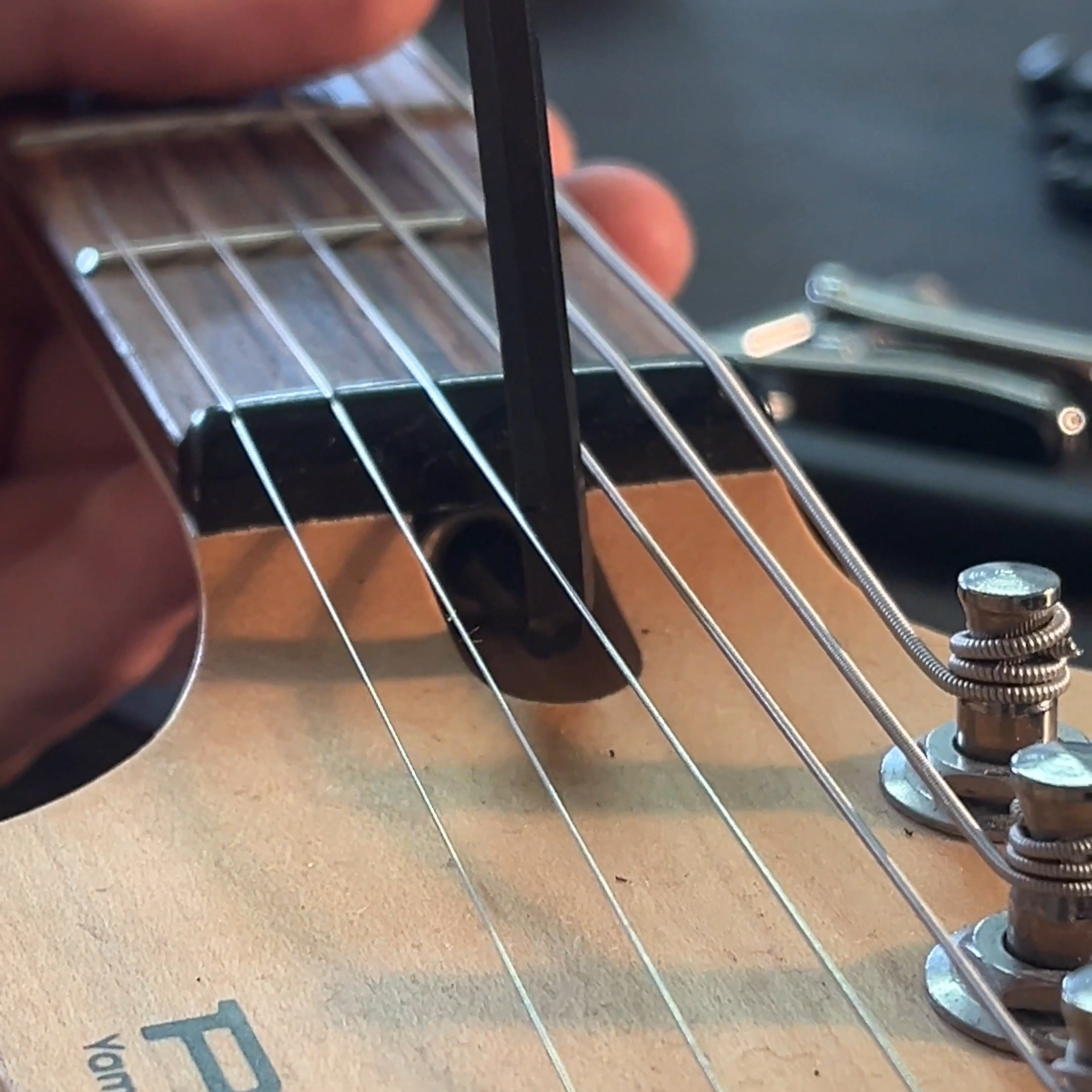 Wie stellt man bei einer E-Gitarre die Halskrümmung ein?