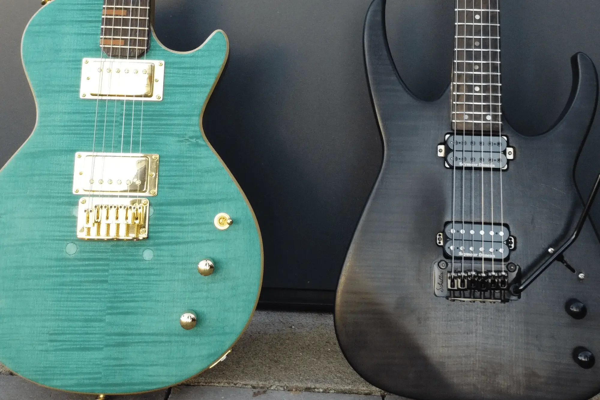 Türkise E-Gitarre neben einer schwarzen E-Gitarre