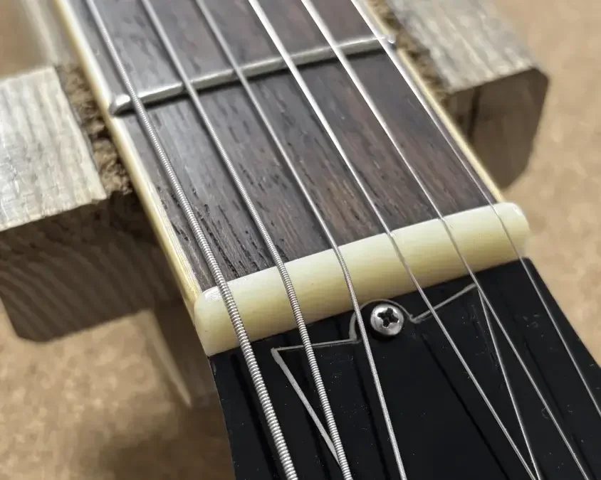 Plastiksattel in einer E-Gitarre