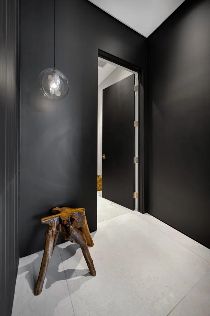 Minimalist black hallway entry with glass pendant light in a luxury South Yarra bathroom renovation