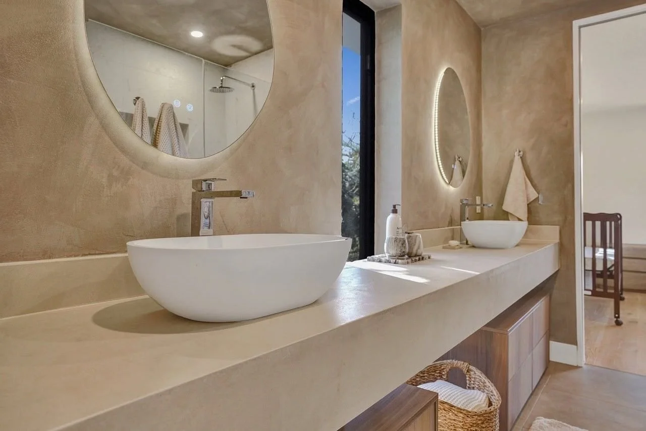 Close up of chrome basin mixer tap against warm microcement walls in an Essendon home