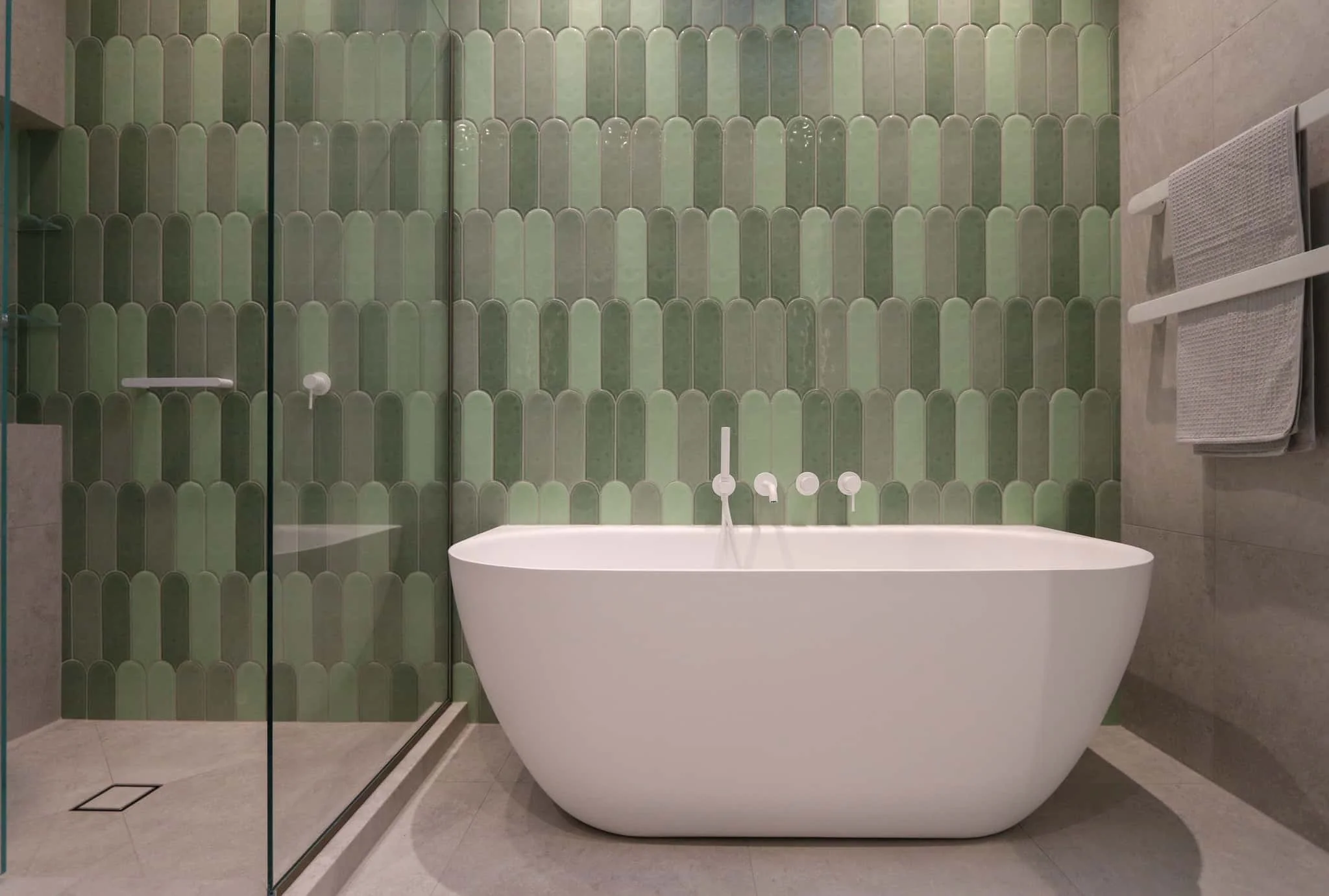 Sage green arching kit-kat feature wall tiles with matte white shower tapware in Strathmore
